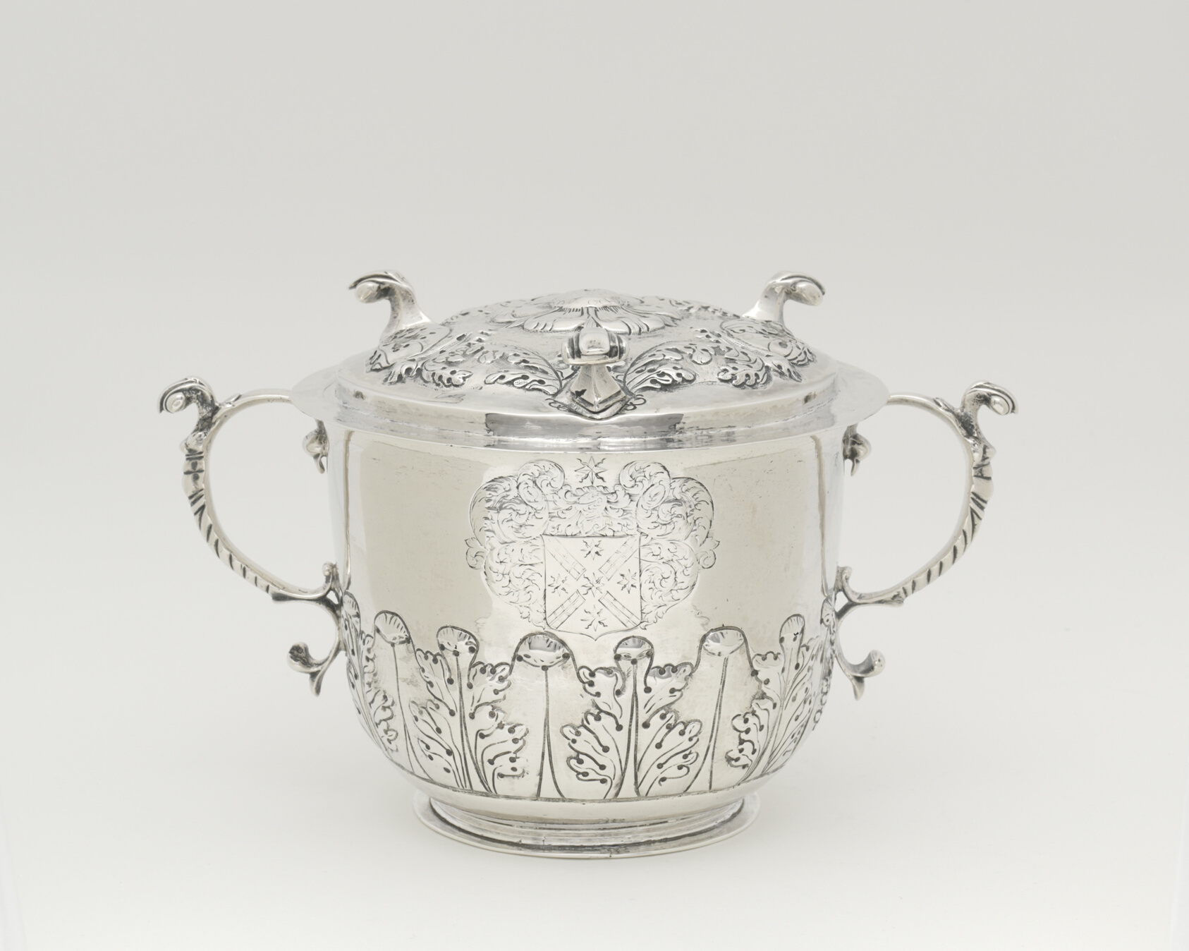 Shiny silver cup with lid, two handles with leaf designs