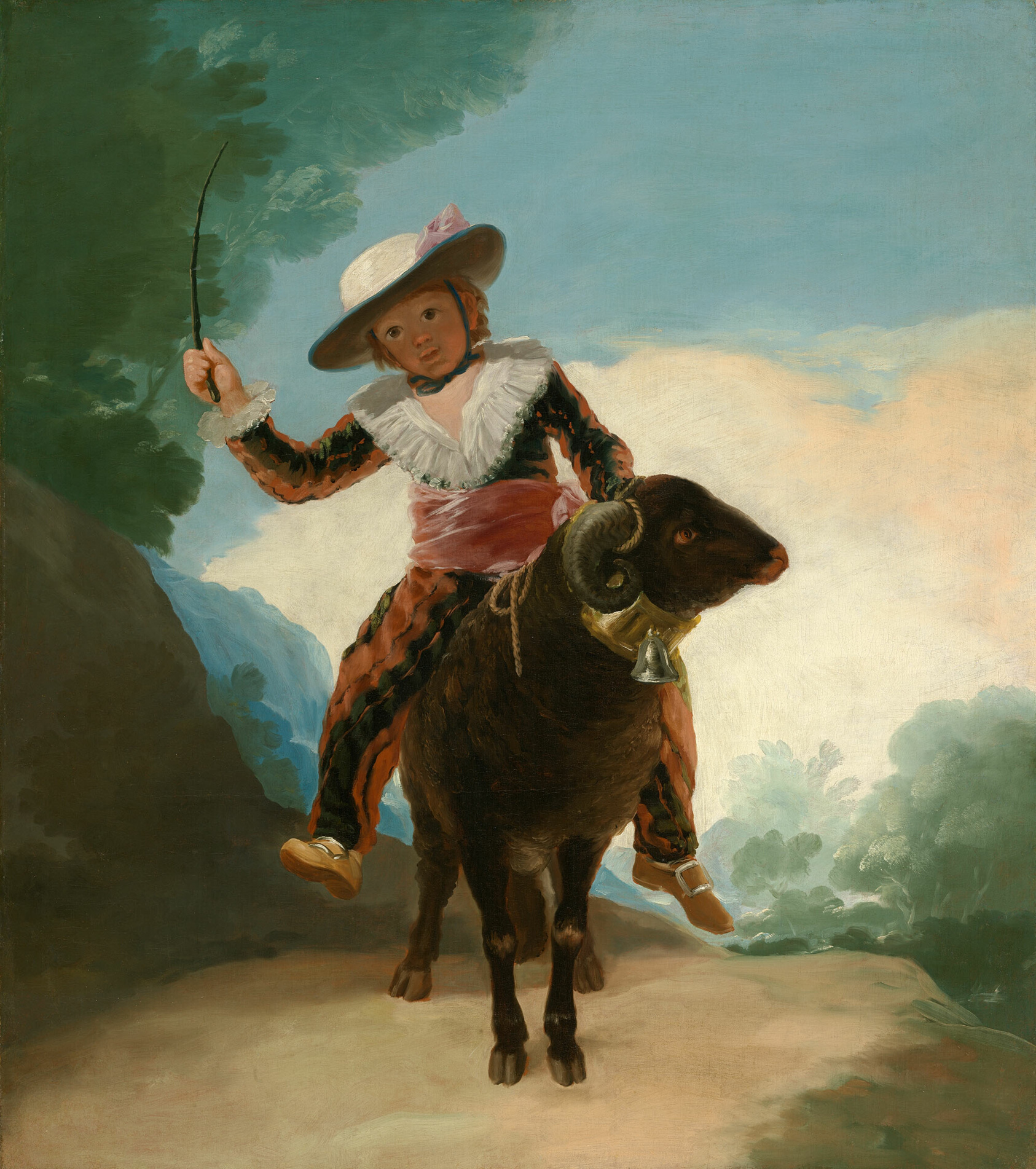 A young, smiling boy in a ruffled collar, hat, and cumberbun rides outdoors on a brown ram, a small whip held aloft in his hand.