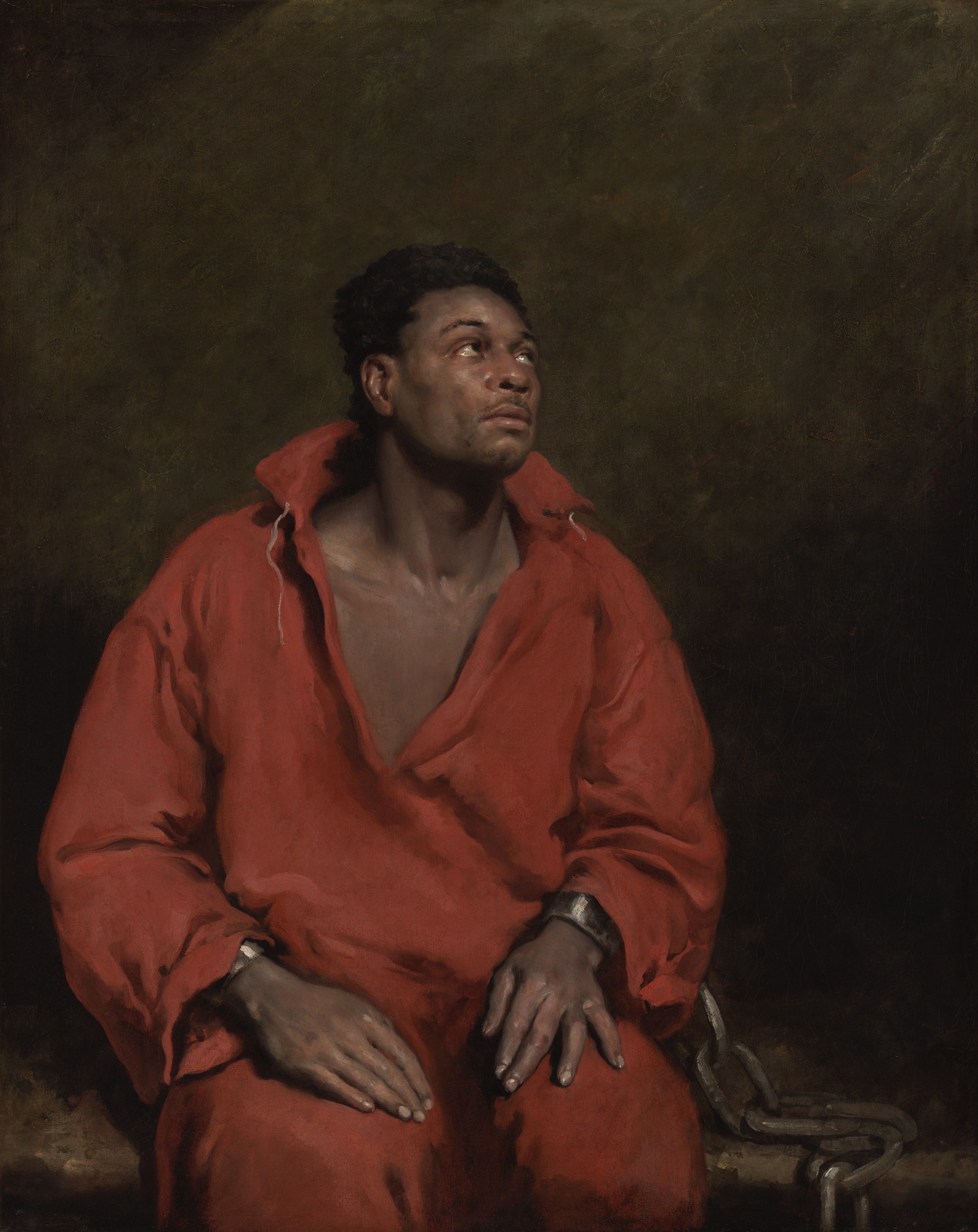 Painting of a dark-skinned man seated and wearing a red open-necked tunic. He looks up to the right. His wrists are shackled and a large chain rests at his right, running down the bench he sits upon.