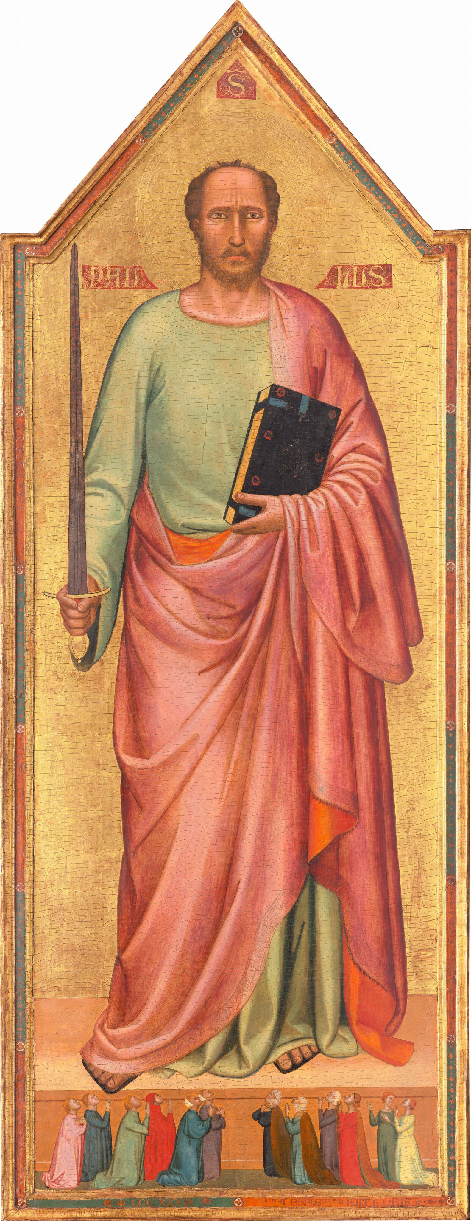 Against a shiny gold background, a man with peach-colored skin nearly fills this tall, narrow, vertical panel above a row of twelve people, significantly smaller in scale, kneeling by his feet and looking up at the man, their hands together in prayer. The top of the panel comes to a point above the man’s head. His body faces us, and he looks at us with brown eyes under furrowed, dark eyebrows. His nose is long and straight, and his mouth is small with a rosy lower lip. He has a brown, trimmed beard, and his hair is receding. He holds up a gold-handled sword with a slate-gray blade in his right hand, on our left, while in his other hand, he cradles a thick black book with a gold-edged pages against his chest. The man wears a floor-length, celery-green tunic with a flowing, rose-pink robe over his left shoulder, on our right, and around his body. The robe is lined with tangerine orange and has a faint, patterned border. The toes of his sandaled feet stick out. On a smaller scale, along the bottom of the painting, six pairs of people kneel facing the center, three couples to each side. Eleven of the people gaze with heads tipped back, up at the man with their hands folded in prayer. To our right, one woman turns and gestures, mouth open, to her neighbor. Their long robes are painted in shades of shell pink, indigo blue, scarlet red, butter yellow, sage green, and chestnut brown. Some wear white fabric over their hair while others are bareheaded. The gold background is incised around the man’s head to create a halo. Molding and a band of alternating strips of slate blue and brick red enclose the pointed panel. Three shapes, like small banners, are painted in red with gold lettering around the man’s head, with an “S” at the top center, “PAU” over his shoulder to our left, and “LUS” to our right. In the blue and red band set into the frame at the lower center, an inscription reads, “NI.MCCCXXXIII M II.ESPLETUM FUIT HC OPUS.” There is a noticeable network of cracks across the painting’s surface, especially on the gold background behind the man.