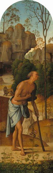 A man stands, leaning on a staff used like a crutch, in a deep, rocky landscape in this round-topped vertical painting. The cleanshaven man has tanned skin and sparse gray hair. He is nude aside from a slate-gray cloth that wraps around his hips. The hand not bracing the crutch is held in a loose fist at his chest. A few plants grow and bloom along the bottom of the panel. The dirt path on which the man stands winds through low, grass-covered mounds to a cave opening at the base of a tall, steep cliff face. A lion stands on the path between the man and the cave. An owl perches in the bare, spike-like branches of a spindly tree growing to our right of the man.