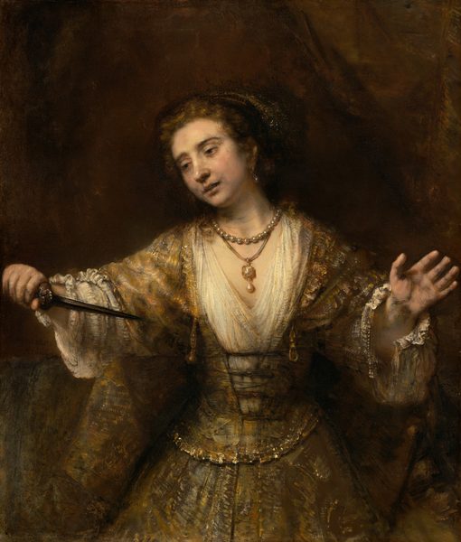 Shown from the thighs up, a pale-skinned woman looks down and off to our left as she holds the pointed end of a dagger toward her chest in this vertical painting. Her lips are slightly parted, and her arms are spread wide as holds the hilt of the dagger in her right hand, to our left. Her hooded, dark brown eyes are rimmed with red. Her head tilts to our left, her pale lips parted. There are gray shadows at the corners of her mouth and along her jawline. Her brown hair is pulled back under a cloth covering painted with white flecks to suggest shiny thread or possibly jewels. She wears a long, tawny-brown gown with diaphanous sleeves. The bodice is laced up over a cream-white undergarment with a deep V neck and voluminous sleeves with unfastened cuffs near her wrists. She wears a large, teardrop-shaped pearl in the ear we can see and two necklaces. One necklace is a strand of pearls, and the other is a gold and possibly jeweled pendant with another teardrop pearl hanging from a cord. A gold belt drapes around her hips over a narrow waist. She is warmly lit from the upper left and set against an earth-brown background. The artist signed and dated the center left, “Rembrandt 1664.”