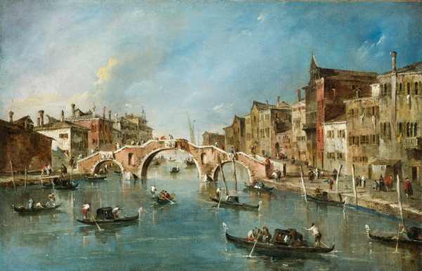From a point of view over the water, we look across a bustling canal at a bridge, which is flanked by rows of buildings to each side in this horizontal painting. At the center of the composition, the pink stone bridge spanning the canal is edged with white stone along its three arches and the top of its stepped deck. At least fifteen people standing or walking along the bridge are painted with touches of dark red, brown, pale yellow, ice blue, white, and black. The canal is busy with gondolas and other small boats, each rowed by standing people with oars. Some boats have covered compartments while others are open with seated passengers. On either side of the canal, tightly packed buildings rise two to five stories high. The architecture includes arched windows, small balconies, and laundry hanging from lines. The colors of the buildings range from pale tan and ochre to darker reds and browns. The street-level areas are active with people walking, talking, or boarding boats. The horizon comes just under halfway up the composition. The sky above is blue with soft, streaked clouds, and sunlight illuminates parts of the scene, casting shadows along the buildings and water.