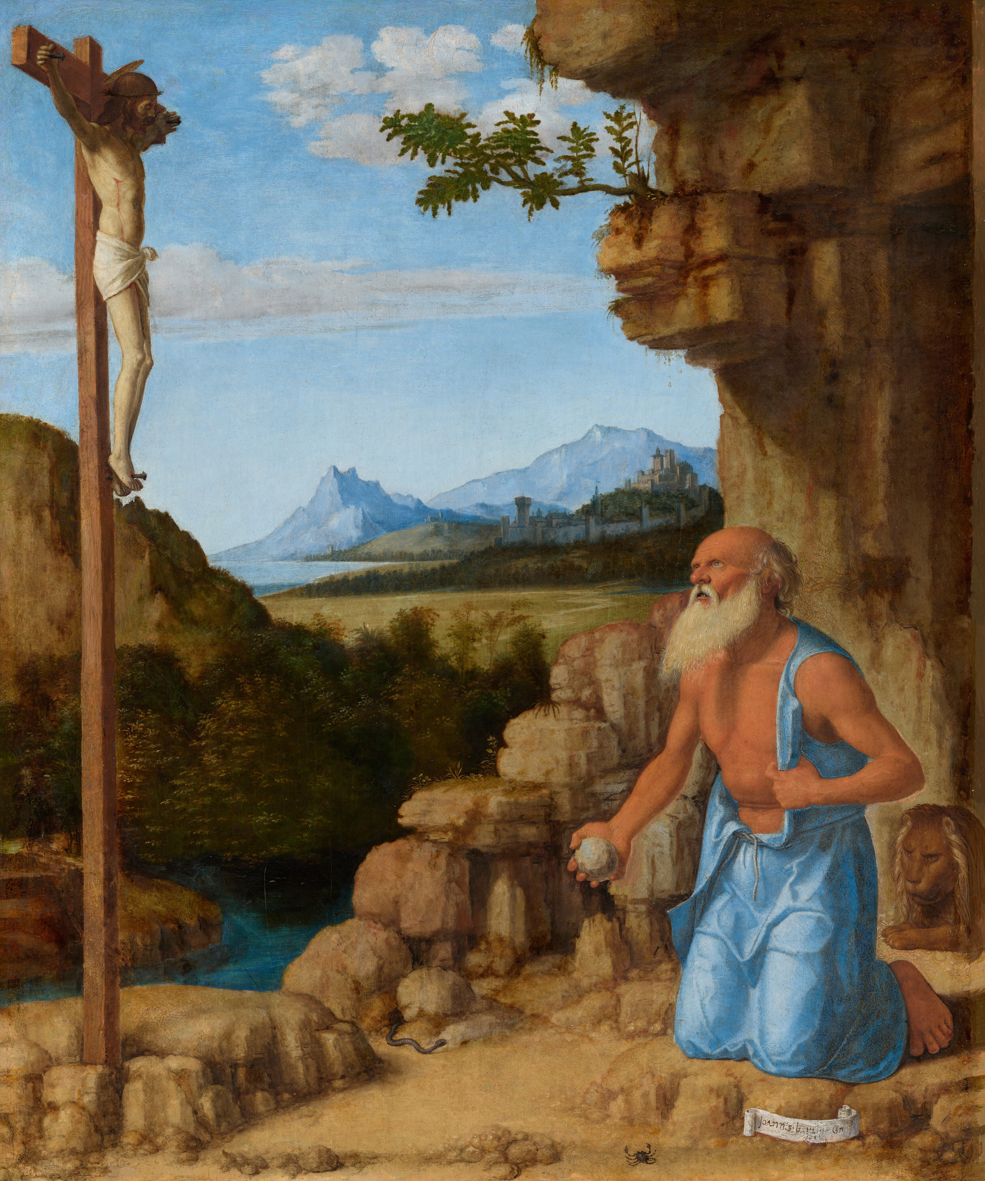 A balding, bare-chested man with a long white beard kneels on a dirt ground to our right in front of a rocky cave opening in this vertical painting. The man holds a rock in one hand and looks up at a man hanging on a cross to the left. The kneeling man, Saint Jerome, has peach-colored skin and a fringe of gray hair. He has a rounded nose, deep-set eyes, a prominent brow, hollow cheekbones, and his lips are parted to reveal two teeth. His body is angled to our left, and he looks up in that direction with blue eyes. His sleeveless, long, powder-blue garment is taken off one shoulder to reveal his chest, and one bare foot sticks out under the hem of the robe behind him. A lion lies under the cave opening, which towers over Saint Jerome and continues off the top edge of the painting. The crucifix is opposite Saint Jerome. The haloed, mostly nude man hanging on the cross is about half the size of Saint Jerome, and has pale skin, brown hair, and a white loincloth across his hips. The wooden cross is braced by rocks. A black snake emerges from a crevice near the base of the cross and appears to head for Saint Jerome. A vivid blue river is glimpsed just beyond this rocky bit of land. Trees and a hill on the far side frame a deep, grassy expanse that leads back to a walled town and pale blue mountains along the horizon. A few white clouds skim across a pale blue sky in the top left quadrant of the painting. The artist signed the work as if he had written his name on a scroll of paper propped up in front of Saint Jerome’s knee, in the bottom right corner of the painting: “Joannis b pt C.”