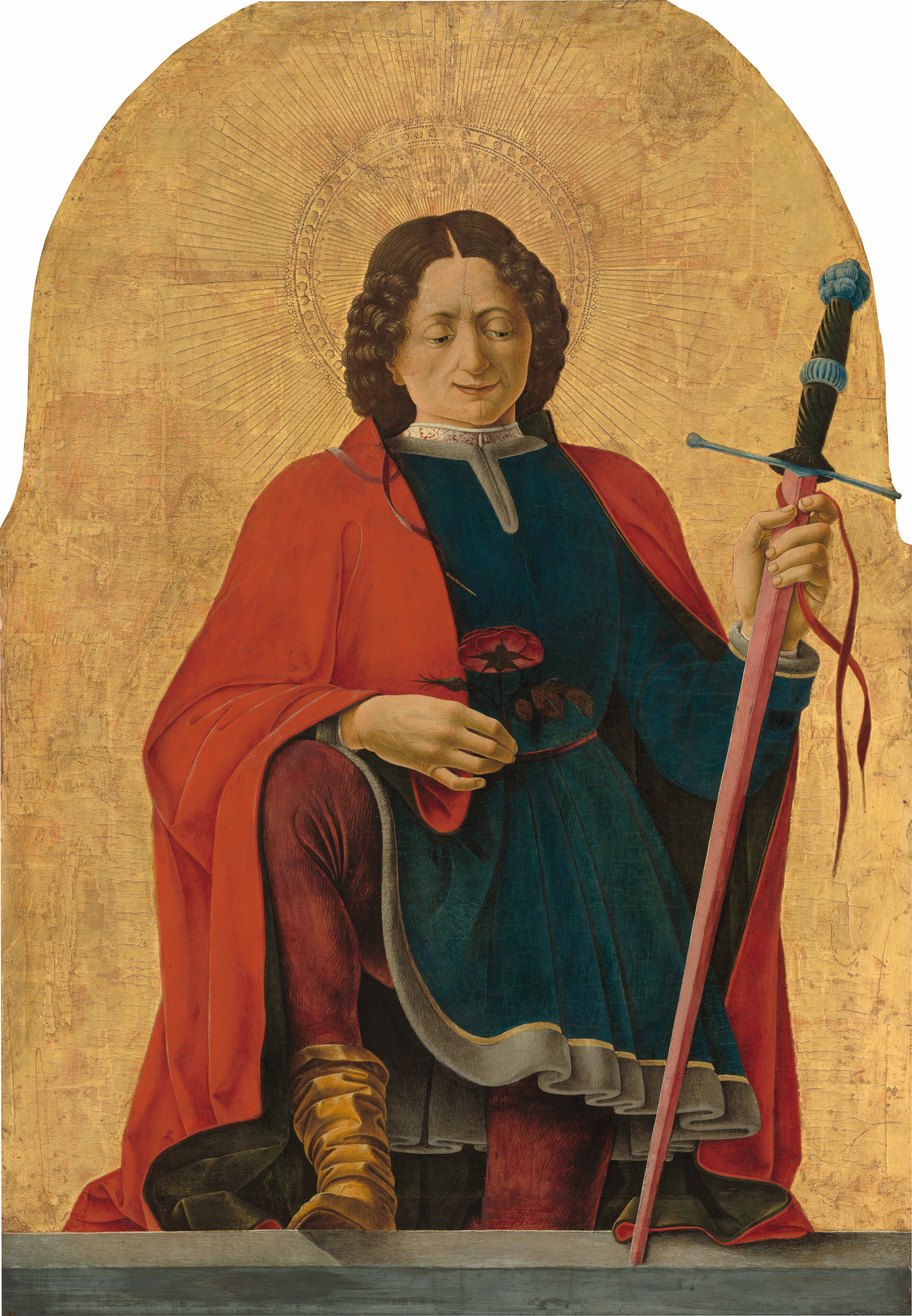 This painting shows a person who faces us, holding a long red sword in their left hand and a red flower with green leaves in their right hand. They appear to be standing, with their right leg bent, resting on top of a gray ledge. They have pale skin and curly, shoulder-length brown hair, arched eyebrows, a cleft chin, and thin lips in a slight smile. They are wearing a dark blue-green tunic with a high white collar underneath a long red cloak, burgundy tights, and tan boots. The arched background is a rich gold color with a halo-like design around the person's head.