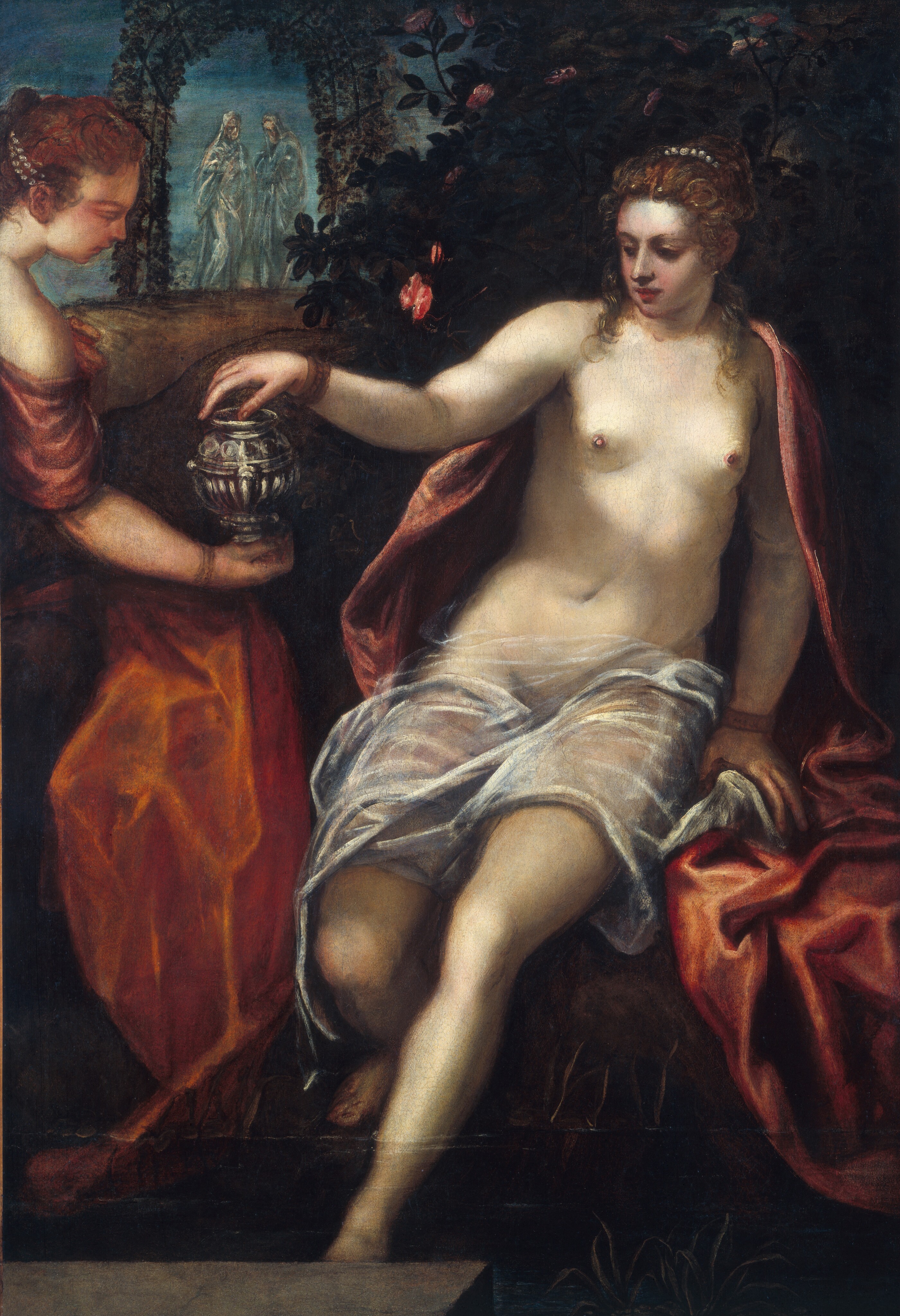 A mostly nude young woman with pale skin leans, half-sitting, back on one hand while she reaches for a silver vessel held by a second woman in this vertical painting. The woman who offers the vessel also has light skin, and both have auburn-brown hair bound up and interwoven with strands of pearls. The body of the woman at the center of the painting, Susanna, faces us and she turns her head to our left, to look at the vessel with shaded, dark eyes. She has a straight nose, and her ruby-red, full lips are closed. A glint on one earlobe suggests a jeweled earring behind curls that frame her face and brush her shoulders. She has small, firm breasts and wears a bronze-colored bracelet on each wrist. Crimson-red cloth hangs from the backs of her shoulders and drapes over her seat. Sheer white fabric covers her lap across her upper thighs. The toes of one foot rest on the ground while the other foot dips into the water of a pool. The other woman, holding the round vessel, faces away from us as she leans into the painting so only her head, shoulders, and arms are visible. Her dark pink sleeve wraps around the upper arm we can see, and she wears a gold-colored bracelet on that wrist. A swath of brick-red fabric hangs between the two women. A dark, shadowy bush dotted with deep pink roses fills the space behind Susanna and, in the distance to our left, two people stand under an arched trellis covered with vines. Wearing light-colored robes and hoods, the people in the distance are painted with silvery gray and cream white, and are translucent against the sky.