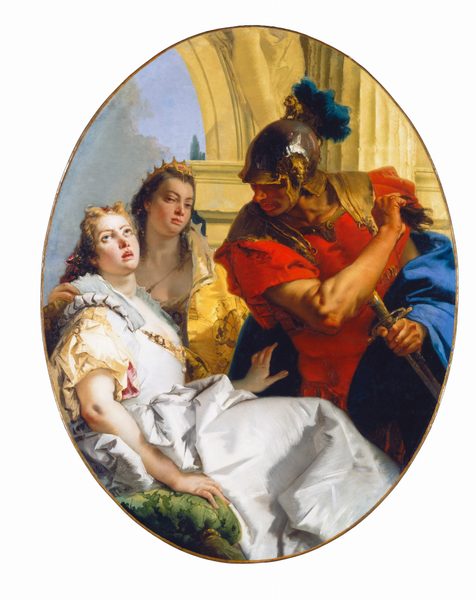 Two women and a man in front of a column and arch nearly fill this vertical, oval painting. The two women have pale skin with round faces, wide-set eyes, and full pink lips. The woman in the lower left quadrant of the painting sits on a moss-green cushion with her body facing our right almost in profile. Her face turns to us and is tipped up, the eyes cast heavenward and her lips parted. She has blond hair and wears a white gown with a voluminous skirt.  A gold and possibly jeweled belt is looped over one shoulder and crosses her torso. Her right hand, closer to us, rests on the pillow and the other is slightly lifted to reach toward or touch the hip of the man to the right. The second woman is behind the first and wears a gold crown tucked into her long brown hair. Her mouth is closed, and her head is tipped slightly back and away so she looks at us from the corners of her heavy-lidded eyes. She wears a low-cut bodice and a buttercup-yellow robe, and one hand rests on the other woman’s shoulder. Dominating the right half of the composition, the clean-shaven man has dark, tan-brown skin. He wears a silver and gold helmet topped with a gold lion and a royal blue plume. His armor is scarlet red, and a lapis-blue cloak wraps across his middle back and over one forearm. He holds a sword in one hand a what looks like a lock of brown hair or fur in the other. He looks down at the first woman with his head tipped toward us so his eyes are hidden by the helmet’s brim. The column and arch behind the trio is pale yellow, and gray clouds, a sliver of blue sky, and the tip of a green tree are visible in the distance to the left.
