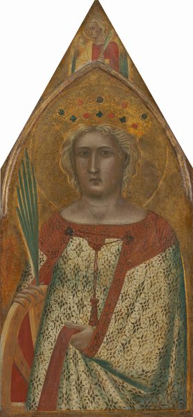 Shown from the hips up, a woman wearing a crown braces a wooden wheel against a gold background on a panel shaped to come to a sharp point at the top of this vertical painting. The woman’s pale skin is faintly tinged with green and gray. Her body faces us, and she looks at us with light brown, almond-shaped eyes. She has a long, straight nose, full cheeks, and her pink lips are closed. Her blond hair sweeps back from her face under the gold crown, which is set with blue and red gems. Her dress and cloak have gold leafy patterns against ivory white, and are edged with brick red. She wraps the cloak around her left elbow, to our right, and grips the fabric in that hand. The other elbow is slung over the wooden wheel, and she holds a palm frond in that hand. A gold halo is incised onto the background. Above the woman, narrow molding affixed to the panel creates a rounded but pointed arch set under the sharp point at the top of the panel. Between the arch and the triangular tip, an angel with yellow and blue wings and blond hair is shown from the chest up. The angel’s body faces us but the head is almost in profile to our left. A narrow palm frond is held by one shoulder, and a butter-yellow cloth drapes over a cardinal-red gown. The surface of the painting is cracked and chipped, especially in the gold areas. 