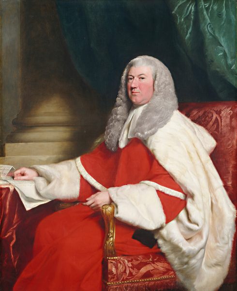 This painting shows a man seated on a decorative red chair, his body turned towards the left and his head turned to look at us. He has a round face, light skin, and gray curly hair that goes down past his shoulders. He wears a red robe with thick white fur trim and rests one arm on a red table or surface on the left. On top of this surface are several sheets of white paper. In the background, there is a stone pillar on the left and draped green curtains on the right.