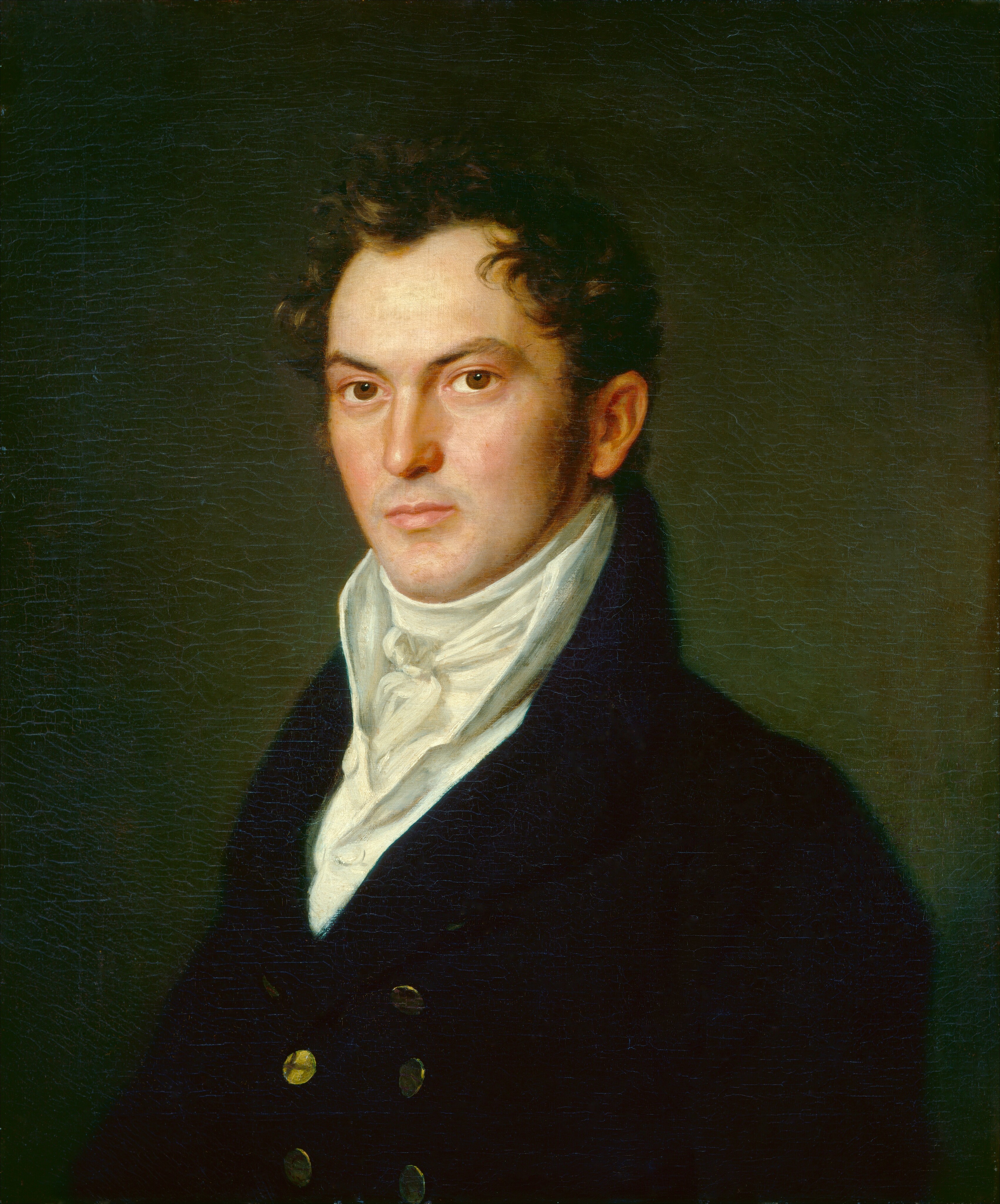 The image shows a man depicted from the waist up, positioned slightly turned to the side yet facing the viewer directly. He has a composed expression with defined facial features, including a high forehead, strong eyebrows, prominent cheekbones, and a clean-shaven face. His hair is dark and curly, styled away from his forehead. He is dressed in a dark coat featuring a double-breasted design with gold buttons, complemented by a high-collared, white cravat intricately tied at his neck. In the background, there is a subtle, dark, greenish hue.