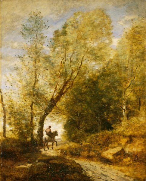 A person rides a horse away from us on a narrow dirt path curving through a forest dominated by golden yellow trees in this vertical landscape painting. A boulder about twice the width of the path is backlit where it sits just left of the lower center of the canvas. The path begins near the bottom right corner of the painting and curves back and to the right. The horse is white, and the rider wears dark brown pants and a hat, and a lighter brown shirt. Trees towering over the rider to either side of the curve nearly reach the top of the composition. The horizon comes less than a third of the way up the painting. Pearly white sky fills in the gap between the trees around the rider, and ivory-colored clouds frame an icy blue sky above. The scene is painted with textured and blended strokes, which gives the painting a soft look even though some of the brushstrokes are visible. The artist signed and dated the lower center of the canvas, though it is partially cut off: “COROT 1872.”
