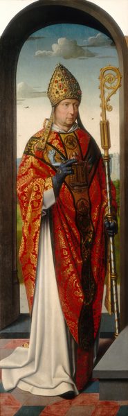 An older, pale-skinned man wearing a richly brocaded robe and bishop’s mitre stands under a rounded arch in front of a deep landscape in this tall, narrow, vertical painting. The man faces our right and has a deeply lined face with light brown eyes under thick brows, a long nose, and a pale, closed mouth. His dimpled chin and jowly neck are tinged with a five-o-clock shadow. The pointed gold mitre on his head is encrusted with pearls and ruby-red, olive-green, and dark gray gems. He wears a long white garment under a scarlet-red and shimmering gold brocaded robe. Bands down the shoulders and front of the robe show angels, an eagle, and a collection of objects. He wears marine-blue gloves and gold rings on both hands. One hand is held in front of his chest, the first two fingers extended. He holds a crozier, a staff with a gold, spiraling top, in the other hand. He stands on a pink and blue tiled floor near a gray step. The arched opening behind him gives way to a landscape with trees, gray stone towers, and distant blue hills under a pale blue sky.