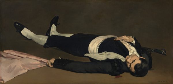 From a low perspective, we look at a man wearing black and white, lying on the ground with a pink flag beside him in this long, horizontal painting. We look onto the top of his head and his feet reach into the upper left corner of the composition, so he nearly fills the painting. His dark hair is cut short and gleams softly in the light from the upper left. His head has fallen toward his left shoulder, and his eyes are closed. He wears a black jacket and knee-length black pants. His jacket falls open to show white lining, and he wears a wide, white cummerbund and white stockings. His black, loafer-style shoes have pointed toes and possibly a bow at the bridge of each foot. He man’s right hand, farther from us, rests on his chest, and a black-handled sword or dagger is tucked into that elbow. That hand and his white tie are speckled with red blood. More blood seeps on the peanut-brown floor near the man’s left shoulder, closest to us. The man wears a gold ring on the pinky ring of his left hand, which lies along the ground and rests on or near the pale pink flag, which continues off the bottom left corner of the painting. The brown ground is lighter along the bottom of the painting and deepens to peat brown farther back, along the top edge. Brushstrokes are visible in some areas, especially in the white parts of the costume and the flag. The artist signed the painting in the lower right, “Manet.”