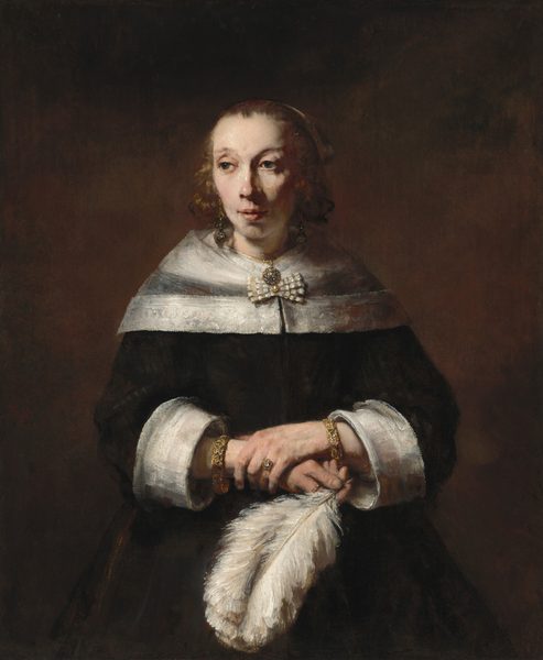 A woman with pale skin, wearing a black dress and holding a full, billowing white ostrich feather, is shown from the hips up against a dark background in this vertical portrait painting. She has dark eyes, faint, arched brows, a slightly pink nose, and her pink lips are parted. Light falls from our left, creating shadows under the other cheekbone and along the side of her neck. Her shoulders are covered by a transparent, white, lace-edged wrap fastened with a bow. Her black dress also has wide, white cuffs, exposing a thick, possibly jeweled bracelet on each wrist. She wears two gold rings, one with a clear gem, perhaps a diamond, gold, dangling earrings, and a round pendant necklace. The lush white ostrich feather arches down from her right hand, held at her waist by her opposite hand, clasping that wrist.