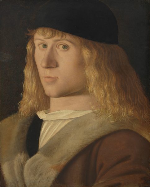 This painting is a portrait of a person's upper body, including their head, shoulders, and a portion of the chest. The individual is facing slightly to the left, looking towards us out of the corner of their eye. They have light-blond, shoulder-length wavy hair and wear a black cap. The person has a fair complexion, light green eyes, a strong jaw, and thin lips in a neutral expression. They wear a brown mantle lined with gray fur over a white garment. The background is dark gray.