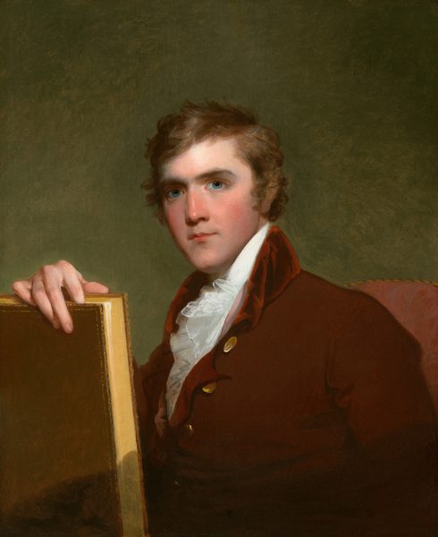 The man in the image is seated and wearing a dark brown coat with brass buttons over a white shirt and ruffled cravat. He has light brown curly hair and is holding a book with a golden cover in his left hand. The background is plain green and the chair he is sitting on is upholstered in red fabric.