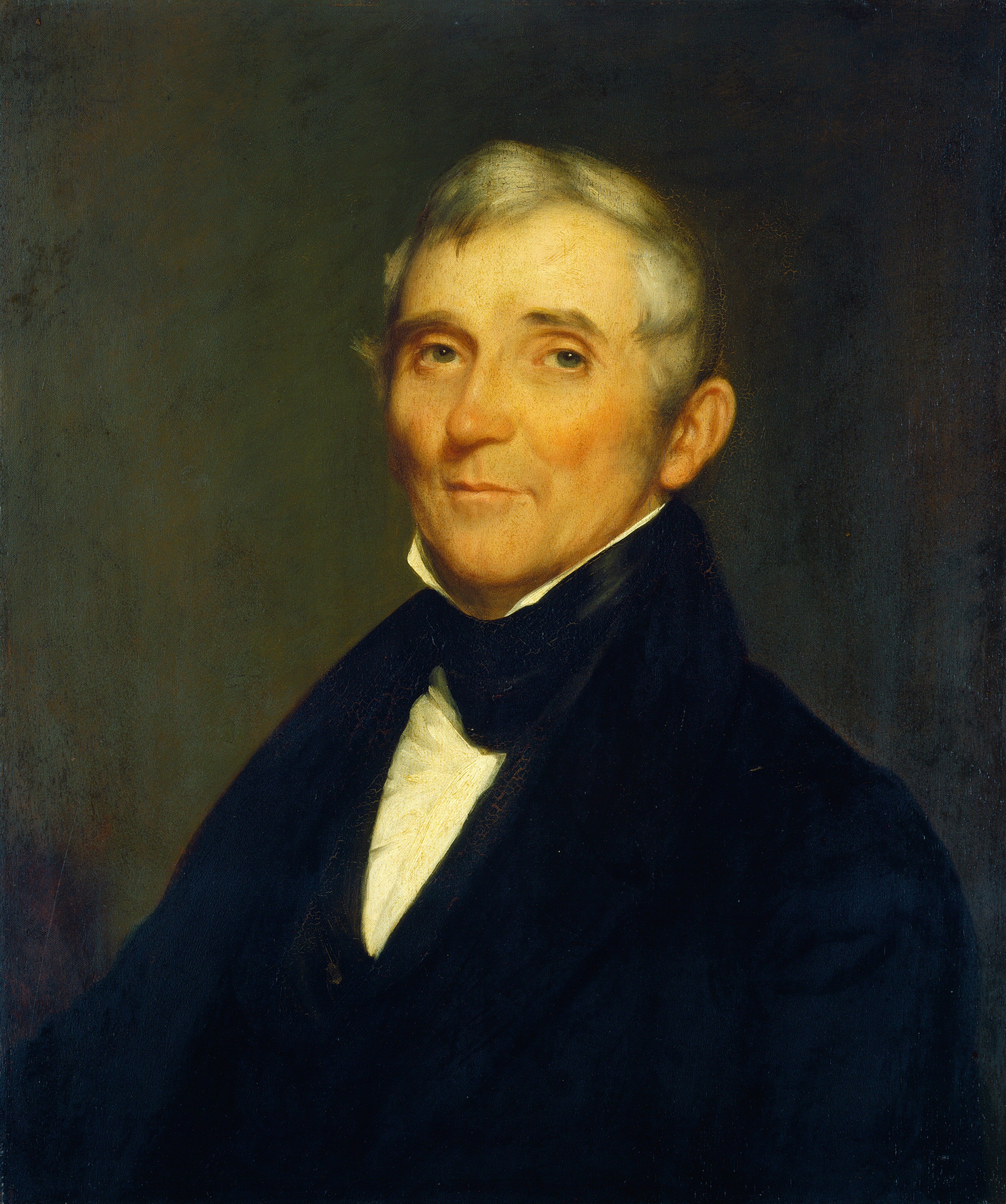 The image is a portrait painting showing a man's upper body. He is positioned slightly turned to his right, with his head facing the viewer. The man has fair skin, defined cheekbones, and small, bright eyes. His hair is short, neatly combed, and grey or white. He is wearing a dark coat over a white shirt with a high collar, partially visible. The background is a muted, dark color, providing a simple setting that emphasizes the subject. There are no visible jewelry or objects in the image.