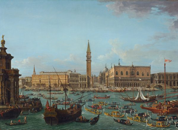 The painting depicts many large and small ships on blue-green water. Gondolas in shades of gold, black, red, and blue drift across the water, small people on them pushing long poles through the water. There are also large sailboats and long boats with several rowers. They create a colorful mix. On the left, a large brown building with columns is visible. Some of the boats pull up to it, and many people in colorful clothing are visible on the shore. Behind the water are more large buildings in shades of brown, cream, and tan, with even more people visible on the streets below them. There is a large tower in the center of the painting, and several blue domes are visible in the distance. The sky is light blue, with white and gray clouds drifting across it.