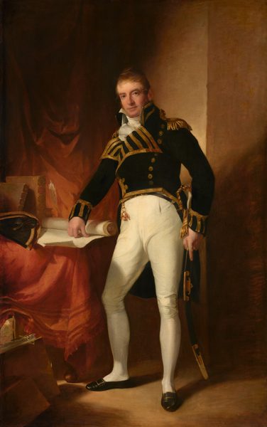This painting shows a man in a naval officer's uniform standing, facing us. He has light skin, thin blond hair, a long nose, deep-set eyes, and thin lips in a slight smile. He wears a black jacket with a wide collar and lines of gold decoration, gold buttons, and gold caps on the shoulders. Under the jacket he wears a high-necked white shirt or cravat and long white trousers. On the left, he holds a rolled-up white document on a table covered in red fabric. On the right, he holds what looks like a long, curved sword by his side, the scabbard black with gold detailing. The walls on the right and the ground below him are a light brown color, while the walls on the left seem to be covered in dark red fabric. Brown books and a black-and-gold hat sit on the table on the left, next to the rolled scroll.