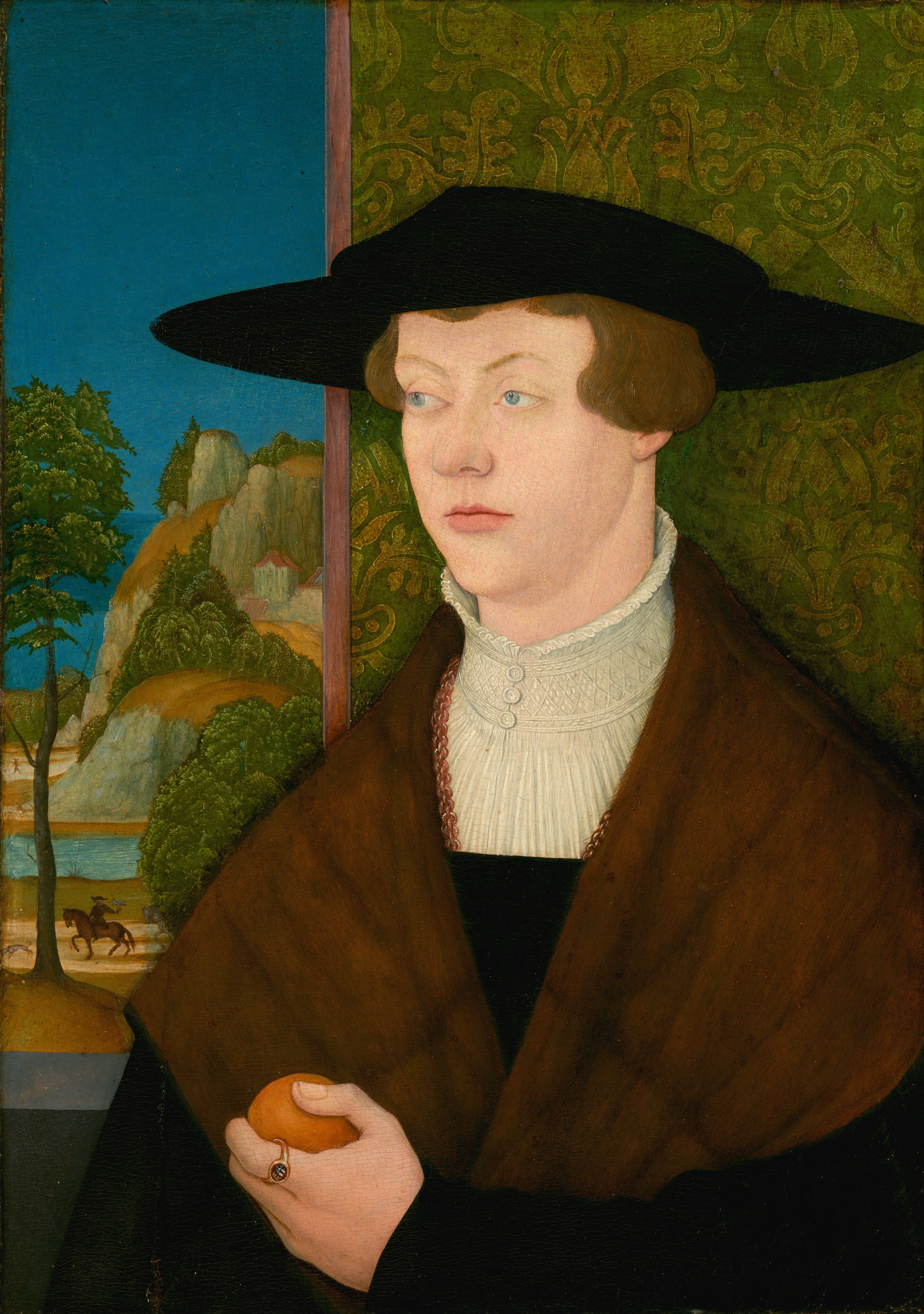 This painting shows a person standing in front of a window, turned slightly to the left. The person has fair skin, light blue eyes, and reddish-brown hair that falls just above their ears. Their pink lips are set in a neutral expression. They wear a flat black hat with a wide rim, and a brown fur mantle over a black garment with a tall white ruffled collar. They are holding a round orange fruit in their left hand, with a small gold ring on their pointer finger. The background on the right appears to be a green wall decorated with a faint yellow pattern. On the left is a window or opening that shows a landscape with a blue sky over a rocky mountain with green trees and small houses with red roofs. Below the mountain is a blue river and a brown road with a rider on horseback visible in the distance.