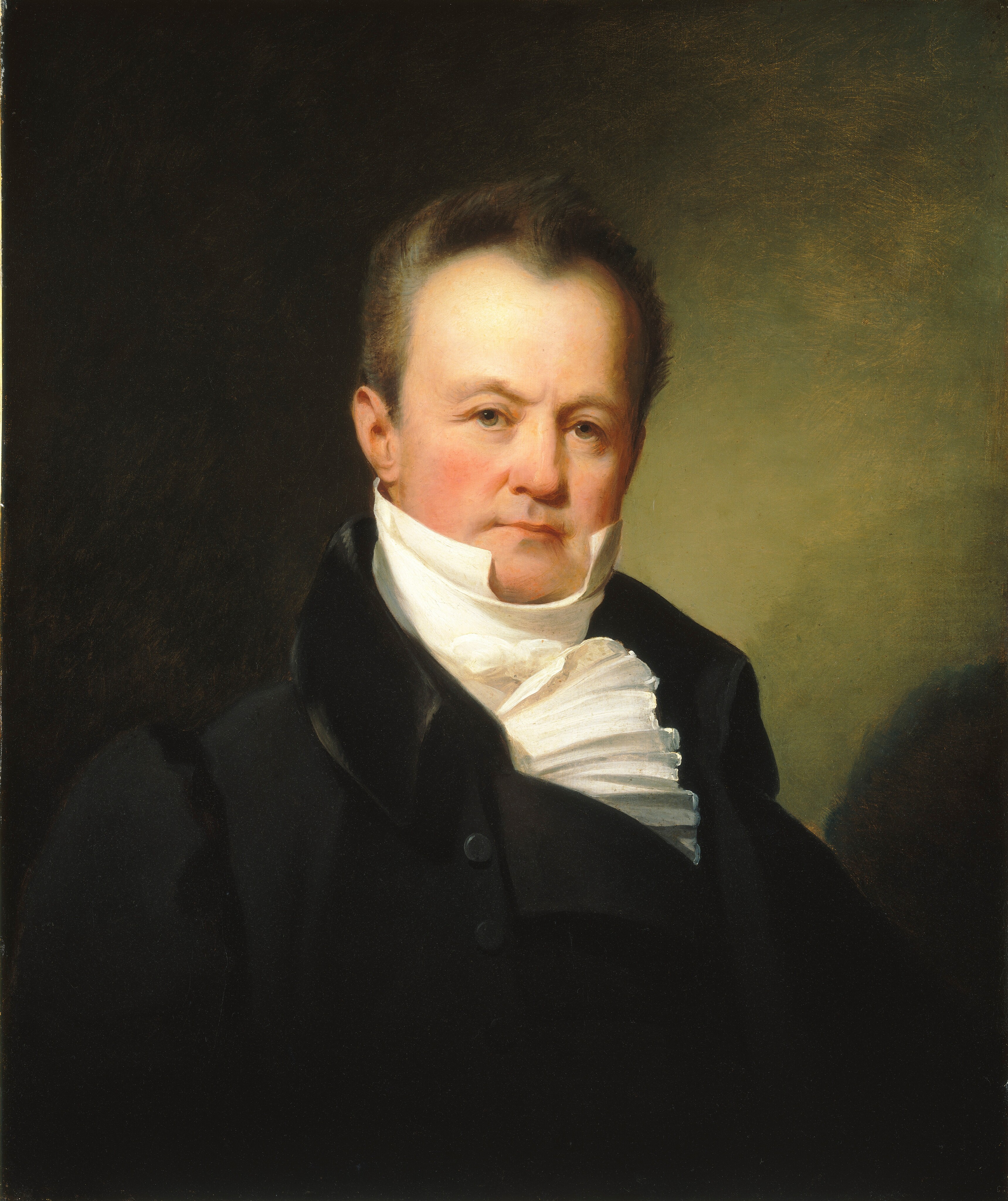 The image shows a portrait of a man, facing forward with his head slightly turned to his right. He has a stern expression, fair complexion, and short dark hair with a receding hairline. He is wearing a white high-collared shirt with a cravat, and a dark coat with a noticeable collar and buttons. The background is a simple dark backdrop.