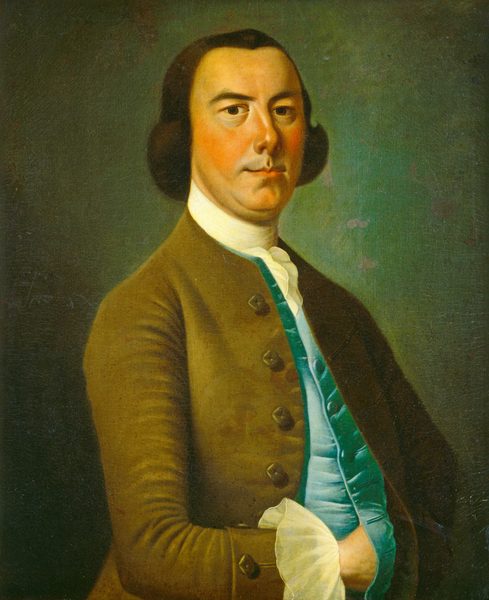 The image shows an upper-body portrait of a man facing forward with his body tilted slightly to the left. He wears a brown coat over a teal waistcoat and a white ruffled shirt is visible at the cuffs and neckline. The man has high cheekbones, a straight nose, and a serious expression. His dark hair is styled in large, slightly curled side parts. The man is set against a plain, muted green background, emphasizing the subject of the portrait.