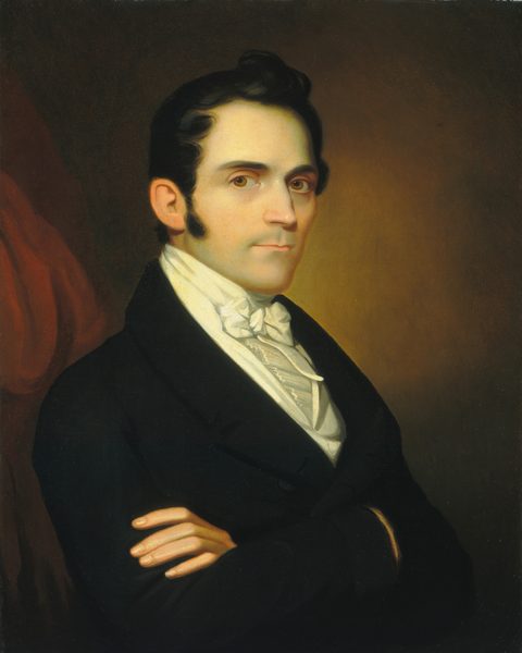 The image depicts a man's upper body. He is facing the left side of the frame but looking directly at the viewer. He has short, dark hair, sideburns, dark eyes, and a clean-shaven face. The man is wearing a black coat over a white shirt with a white cravat. His arms are crossed in front of him. The background has a gradient from dark to light brown, with a hint of red drapery on the left.