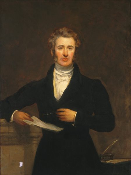 The painting depicts the upper half of a man standing straight and facing us. He has pale skin, rosy cheeks, a long nose, strong brows, and sideburns that lead to his curly, gray-brown hair. He is wearing a black coat over a high-collared white shirt. In one hand he holds papers, while in the other hand he holds a pair of nearly-invisible spectacles against his torso. His right arm is bent and resting on a surface next to him on the left, and there is an inkwell with a quill and a paper on a lower desk or surface on the right. The background is dark brown with some visible brushstrokes.