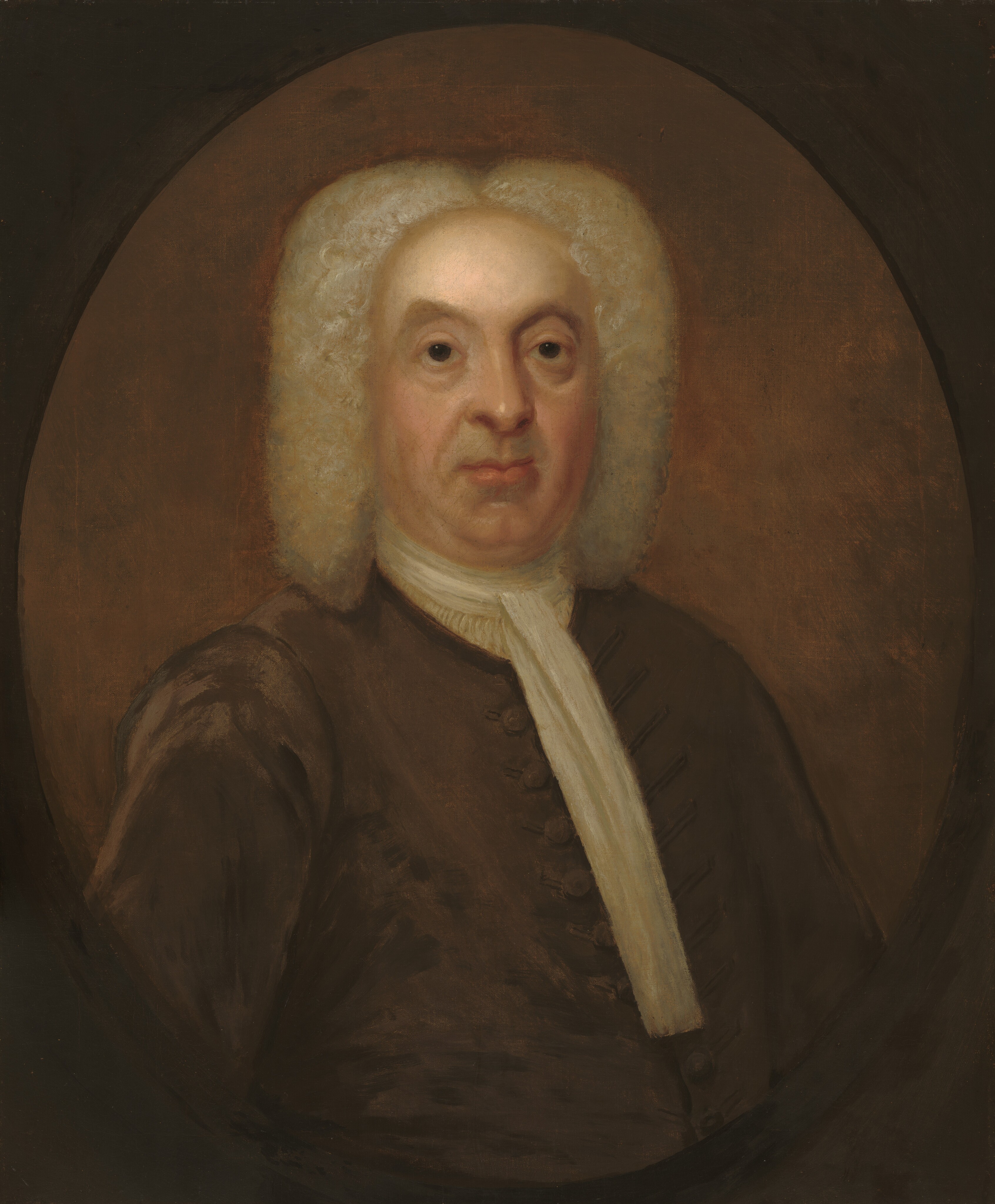 The image features an older man with distinctive facial features and white curly hair, dressed in formal attire against a plain brown background.