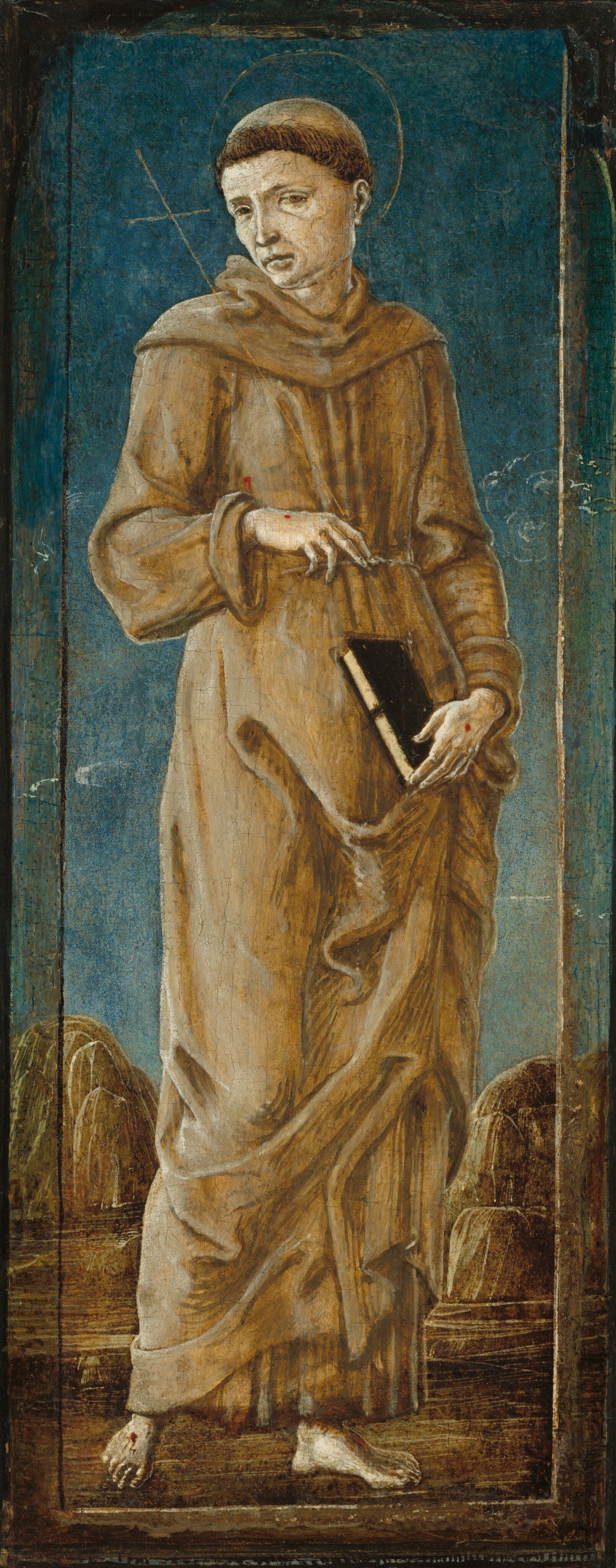 The image depicts a full-body standing person facing the front. The person is tilting their head down and holding a book in one hand. They have a solemn expression, short dark hair with a tonsure, and wear a brown robe with long sleeves, tied with a rope around the waist. The person is holding a black book with a white spine in their left hand. A faint halo surrounds their head. The background is textured blue with abstract forms and rocky formations.