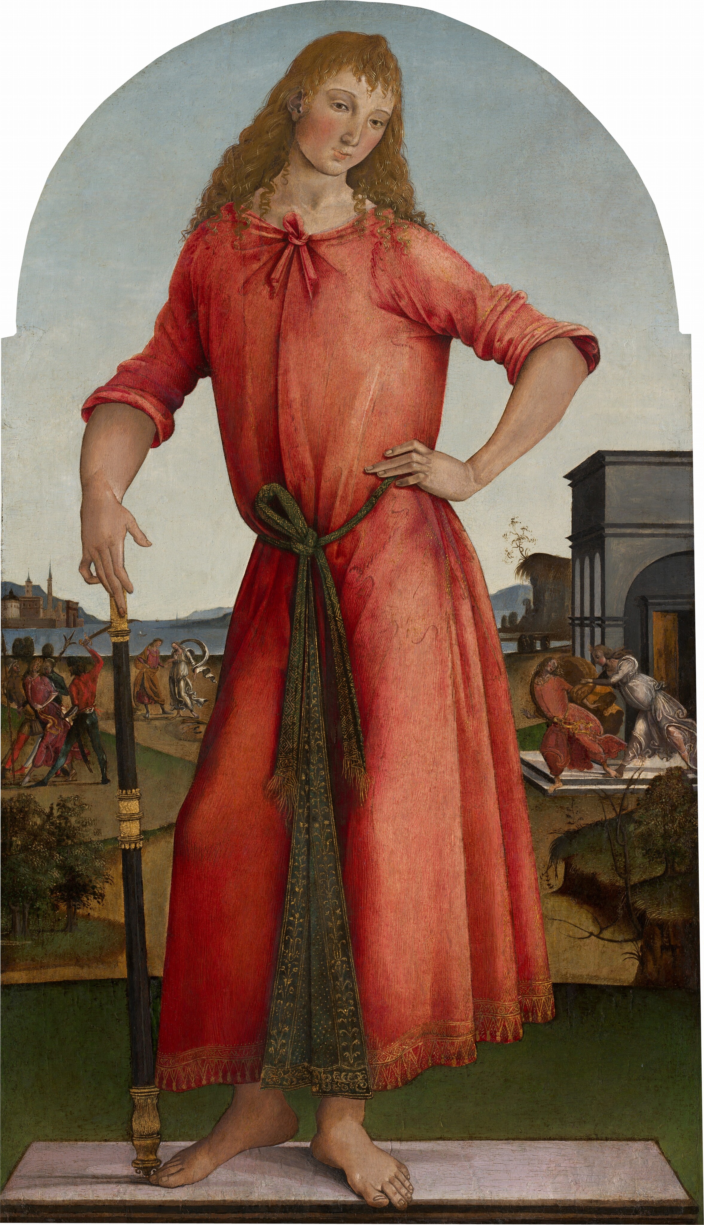 This painting shows a person standing on a small rectangular platform, with one knee slightly bent and the heel of that foot raised off of the ground. The person has pale skin with rosy cheeks, arched eyebrows, brown eyes with dark lashes, small lips in a neutral expression, and long, wavy yellow hair. They are wearing a red robe with a knot around the neckline and a green sash with gold designs around the waist. They are barefoot, and their left hand is on their hip while the other is holding a black staff with gold details at the top, bottom, and middle. The background features a green landscape with buildings, small trees, and a distant body of blue water. There is a gray building on the right, and in front there are two people, one seeming to chase the other. There are more people on the left, including one person who is being restrained by two other people, with a third person holding a sword over them. The people wear clothes in shades of pink, red, green, and silvery gray. The sky above is pale blue. The top of the painting is arched.