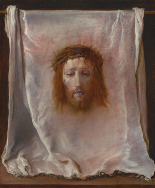 The head and pale face of a bearded man with a ring of interwoven branches of thorns over his chin-length, wavy, reddish-brown hair floats against a white cloth that has been hung over a wooden rod in this vertical painting. The cloth fills the composition. At its center, the man’s head faces us and he looks down with heavy-lidded, brown eyes. His lips are parted, and his cheeks are slightly sunken and shaded with pale lilac purple under high cheekbones. Blood drips down the man’s pallid forehead from the thorns. A brown spot high on his right cheek, on our left, might be a bruise or injury. A soft brown glow surrounds the head. The white cloth is frayed along its front edge, where it rests facing us on a wooden surface along the bottom edge of the painting. The cloth is bunched a little to each side where it drapes over the wooden rod above. The white cloth is painted with tones of pale coral pink, icy blue, silvery white, and dove gray. The background behind the cloth is black.