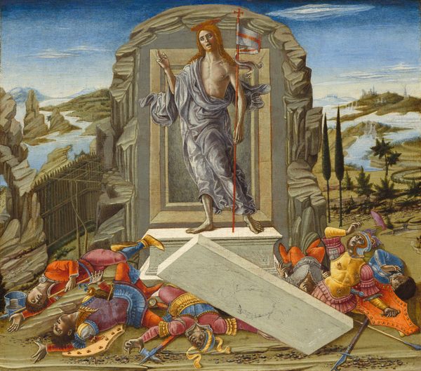 A pale-skinned man stands in front of a door-like opening set into a rocky cave against a deep landscape in this nearly square painting. The man, Jesus, has long reddish-blond hair, a red beard, and a disk-like gold halo. A muted lavender-purple cloth drapes over one shoulder, across his partially bare, muscular chest, and around his hips and legs. His right hand, to our left, is raised with the first two fingers lifted. A tall staff tucked into his other elbow has a long, white banner with a red cross, a forked end, and a red, plus-shaped cross finial. Behind Jesus, a rectangular doorway with molding is surrounded by craggy stone. The man stands on a chest-shaped stone tomb, and a white stone slab lies across the ground in front of it. Six men with pale skin lightly tinged with gray lie under and around the slab. They wear armor in shades of canary yellow, rose pink, aquamarine blue, violet, and orange. Five of them lie with legs and arms akimbo and one, to our right, props himself on one elbow and looks up at Jesus. Pebbles are strewn in a loose line across the ground along the bottom edge of the composition. Rivers zigzag back through more rocky formations and mountains to a town in the deep distance to the right and pale blue mountains along the horizon, which comes three-quarters of the way up this composition. A few thin clouds drift across the sky that deepens from pale yellow over the mountains to deep blue across the top edge of the painting,