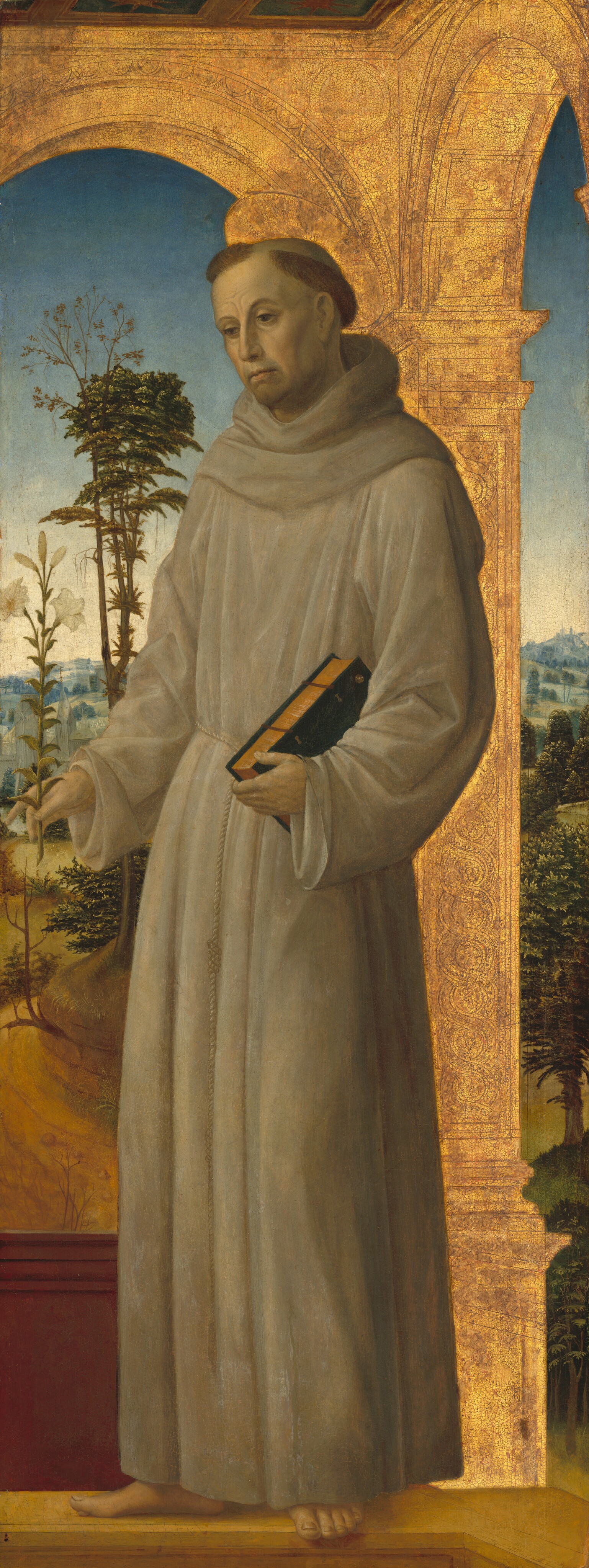 The image shows a man standing upright. He has short hair with a shaved top, wearing a brown robe tied at the waist. In his hands, he holds a small branch with white flowers and a closed book. The background includes trees, hills, and a blue sky. A golden decorative structure frames the scene.