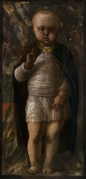 Nearly filling this vertical painting, a young, light-skinned child stands with a delicate scepter tucked into one elbow as he holds up his other hand with the first two fingers raised. The child is lit from our left, but the overall tone of the painting is shadowy and dark. His body faces us, and he looks off to our right with round, deeply shaded eyes. He has short blond hair and a tall forehead, chubby cheeks, and his bow lips are parted. Short, gold rays emanate from the sides and top of his head within a thin gold band to create a halo. He wears a thigh-length, white tunic, and more of that fabric is wrapped around his torso. His dark, burgundy-red cape falls open across his shoulders and down to his calves, and is edged with gold around the collar and down the front. A rectangular, jewel-encrusted gold clasp holds it closed at the throat. He stands with most of his weight on his left leg, to our right, on bare feet. His right hand, to our left, is raised to his chest with the first two fingers extended up. The delicate silver scepter he holds with his other hand is topped with a cross. Swirling patches of muted brick red, harvest yellow, pine green, and off white behind him could be a tapestry. A thin, dark band creates a border around the edges of the painting.