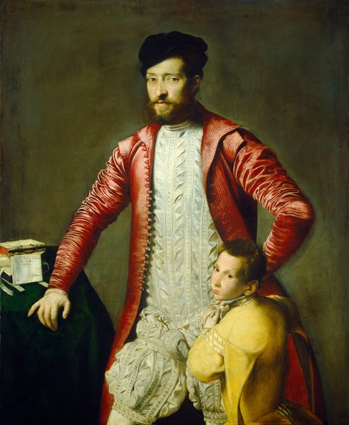 This painting depicts two people, an adult man and a young boy. The man is seen from the knees up, standing with one arm on a table and the other on his hip. He has light skin, light green eyes, a brown beard and mustache, and dark hair under a black cap. He is wearing a bright red jacket with several buttons down the front, which is open to reveal a white garment with several pleats and folds. The boy, who has short brown hair and fair skin, leans against the man's leg, tying a bow on the white garment and looking over his shoulder at us. He wears a yellow outfit with subtle white stripes. On the left is a table covered with dark green fabric which the man has his hand on; there are three books on it, and a letter on white paper propped up against the books. The background is a muted green-brown color.