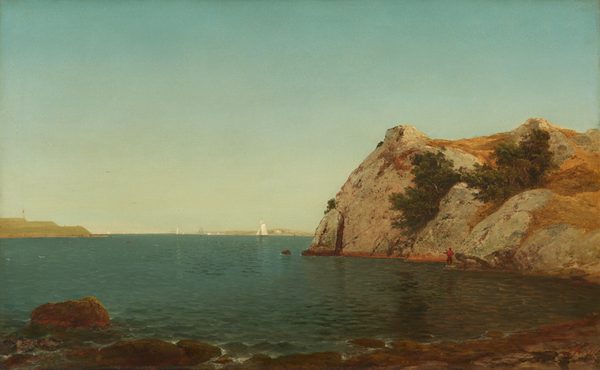 We look across a dark, aquamarine-blue body of water at a bulky, stony outcropping to our right in this horizontal landscape painting. The horizon comes about a third of the way up the composition, and the sky above is pale blue, lightening to almost white along the horizon. Close to us, gentle waves break over rocks and boulders along the beach. The face of the rocky outcropping to our right rises vertically from the water and is tan and caramel brown, with some dark green vegetation growing in its crevasses. At its foot, down by the water, a lone fisherman with a pole stands on a rock casting his line. He wears a red shirt and brown pants, and is tiny in scale next to the rock formation. Farther in the distance, to our left along the horizon, a spring-green spit of land extends into the water. White boats with full sails are visible in the distance. One boat is silhouetted against a far, sunbathed shore.