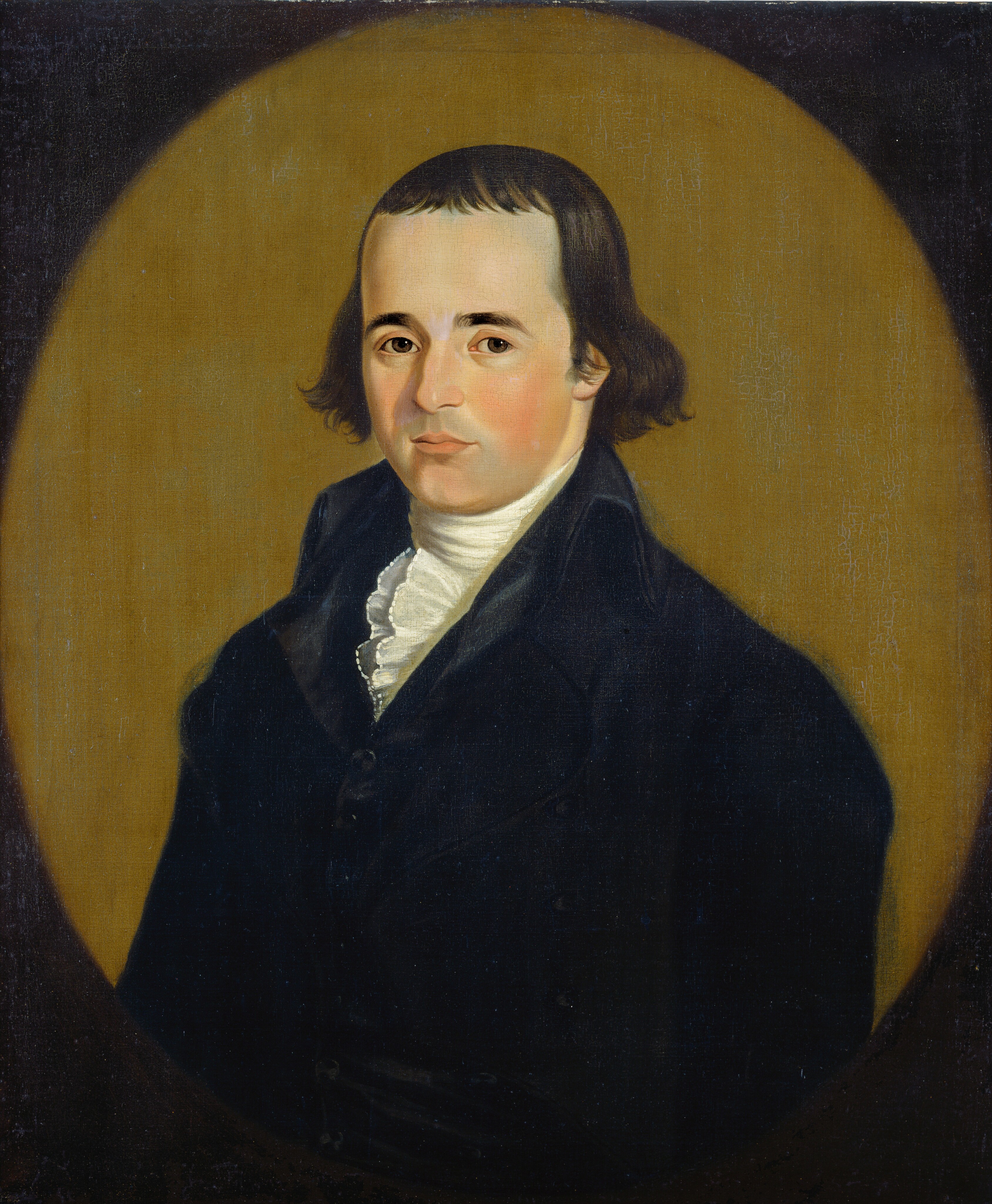 The image depicts a man's upper body. He is facing slightly to the right and has an oval face with fair skin. His facial features include evenly spaced eyes, a straight nose, and closed lips. He has brown, medium-length hair that is parted in the middle. He is dressed in historical attire, wearing a dark coat over a high-collared white shirt with an intricate ruffled design at the neck. There are no visible jewelry or objects in his hands. The background is a warm golden-brown color, encircled by a darker border.