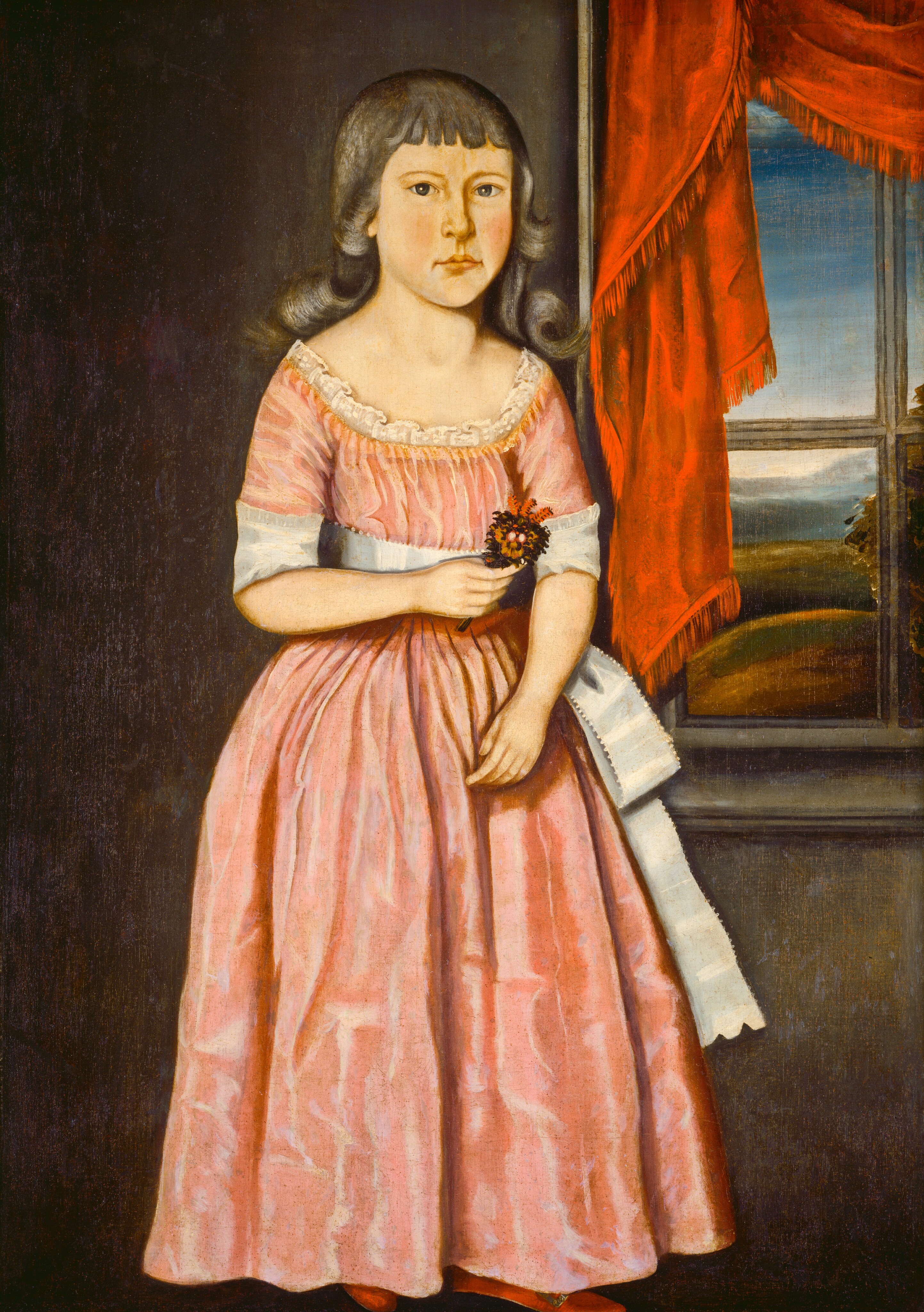 The image shows a young girl standing next to a window. Her eyes are looking directly at the viewer. She has fair skin, dark eyebrows, and dark hair with bangs. She is wearing a pink dress with short sleeves, a white ribbon tied around the waist and sleeves, and lace at the neckline. She is holding a small bouquet of flowers. The background features a red curtain beside the window and a view of a blue sky and greenery outside.