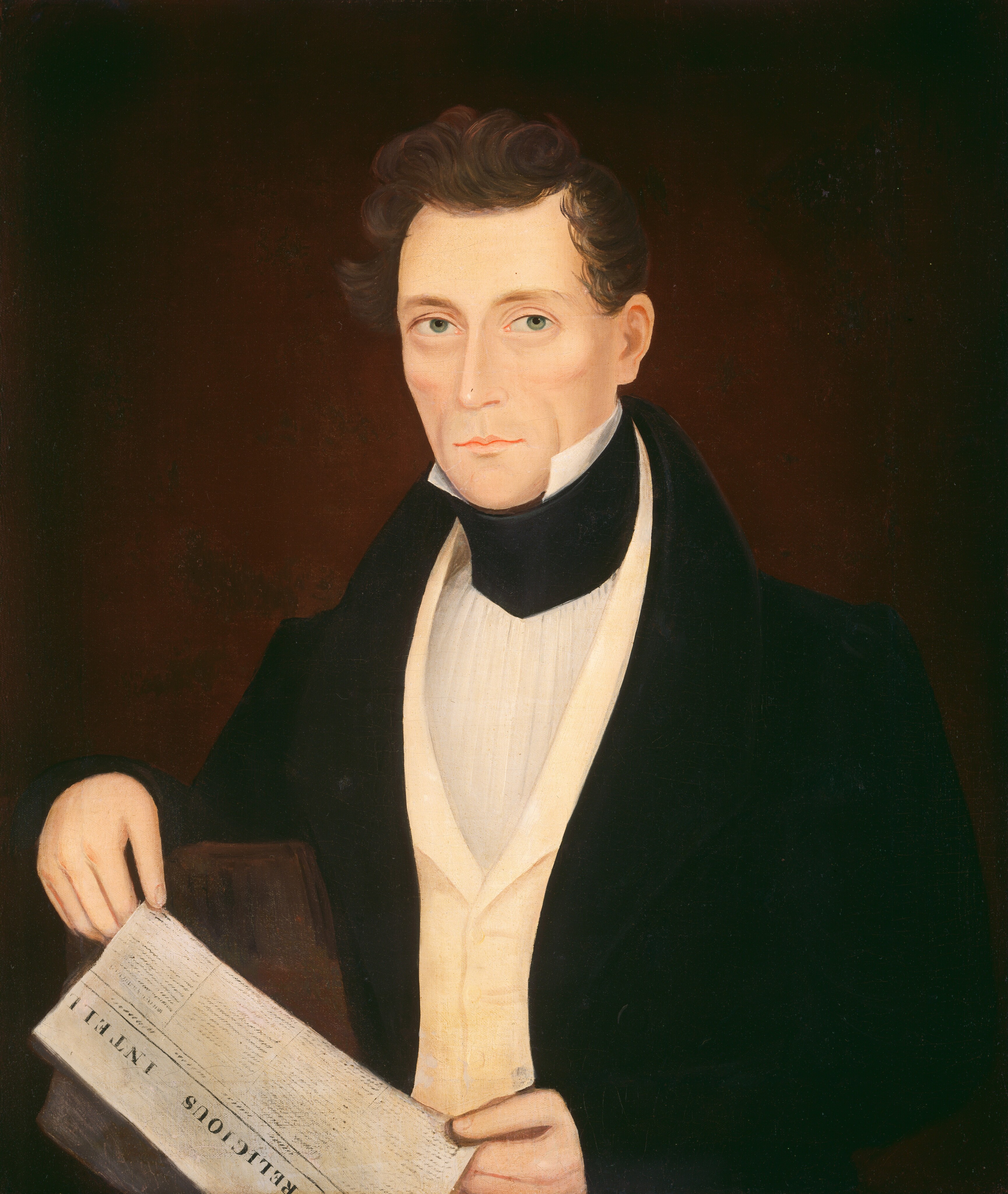 The image shows a man from the waist up. He is facing slightly to the left but gazing directly at the viewer. He has fair skin, light-colored eyes, and short, wavy brown hair. His facial expression is composed and neutral. He is wearing a white collared shirt with a high, stiff black neckband, a creamy yellow waistcoat, and a dark formal jacket. In his right hand, he holds a paper titled "RELIGIOUS INTEL." The background is a deep plain brown color.