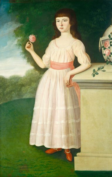 This painting shows a young girl in a full-length portrait. She is standing with her body slightly angled to the left and her left arm resting on a stone pedestal. The girl has light skin, straight brown hair with bangs, dark eyes, and a calm expression on her face. She wears a light pink dress with puffed sleeves, a fitted bodice, and a full skirt with lace details. A pink sash is tied around her waist, and she wears red shoes. She holds a pink rose in her right hand. The background features a lush green garden with dense foliage and a partly cloudy blue sky. The stone pedestal beside her appears to have a vase holding roses.