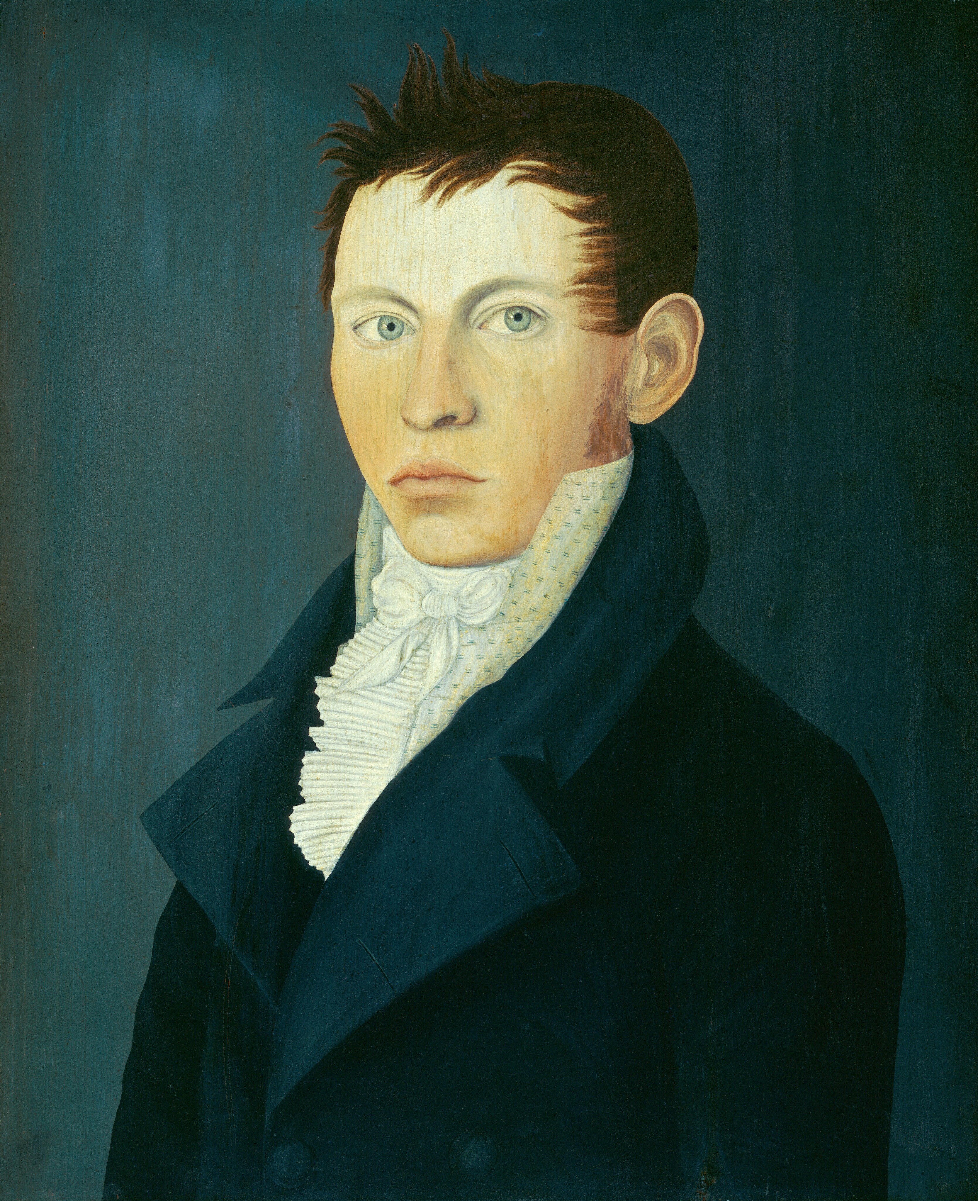 The image shows a portrait of a man's upper body. The man has a serious expression and wide eyes, with short dark hair styled in an upward manner. He is dressed in a dark coat and a high collared white shirt with a decorative front. The background is a solid dark teal color.