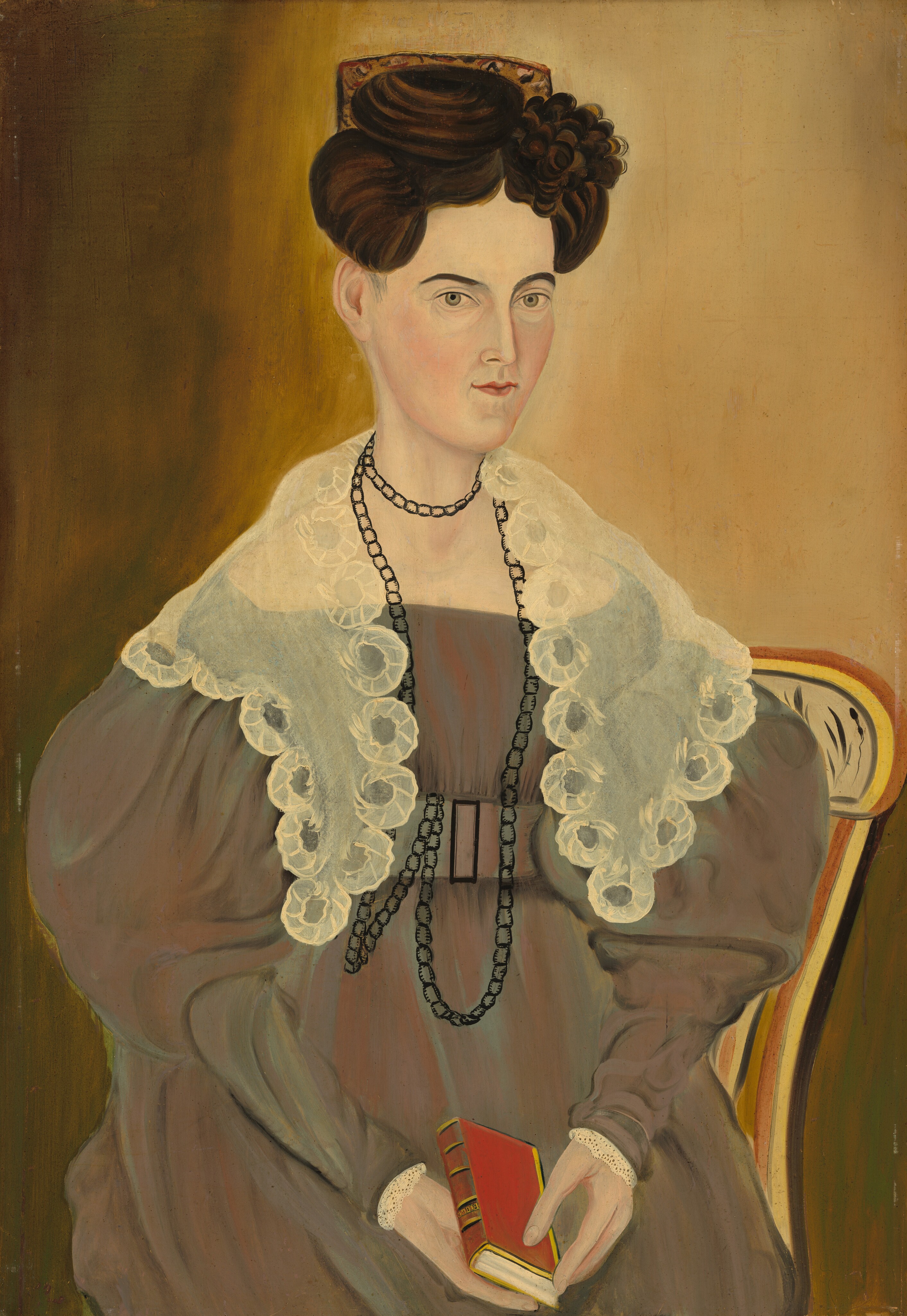 The image shows a portrait of a seated woman. She is sitting upright with her arms relaxed, holding a small red book. Her facial features are detailed, with a fair complexion, high cheekbones, and a slightly serious expression. Her dark hair is styled in an elaborate updo with a floral embellishment. The woman wears a formal, high-necked brown dress with voluminous sleeves, and a transparent lace-like cape draped over her shoulders. She has a long, black beaded necklace layered with a shorter one. The background is a muted, earthy tone with texture.