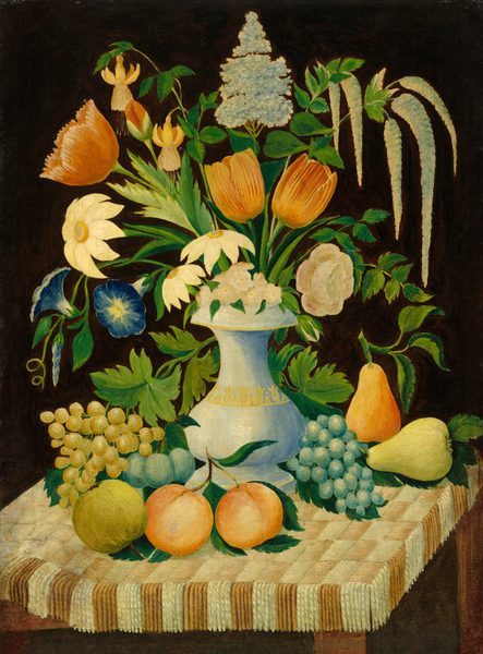 This painting shows a white vase with gold trim and light blue shadows sitting in the center of a table, which is covered in a brown-and-white checkered cloth with fringed edges. The vase holds colorful flowers like tulips, daisies, and roses in shades of white, red, blue, orange, and pink, and the flowers are surrounded by green stems and leaves. On the table around the vase are several grapes, pears, and peaches in shades of yellow, pink, and blue-green. The background behind the vase and flowers is black.