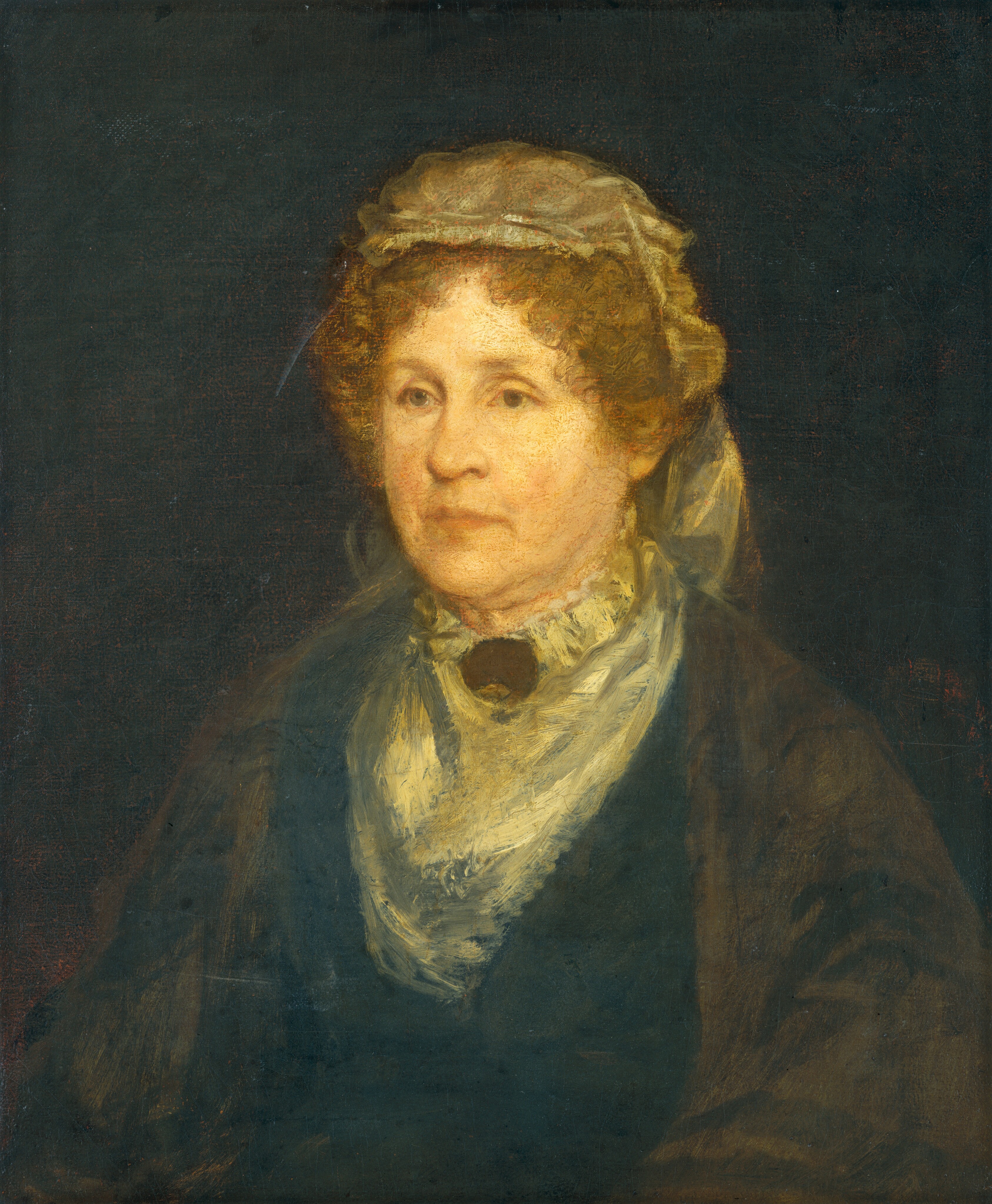 The image displays a head-and-shoulders portrait of a person seated and facing slightly to the left. The individual has a fair complexion with soft facial features, including gentle eyes, a prominent nose, and light-colored lips. Their hair is curly and short, with a light brown hue, and is partially covered by a modest cap with a soft fabric tied at the back, which appears to be of the same texture as their neck scarf. The person is wearing what appears to be a dark-colored coat over a lighter garment, possibly a high-collared blouse or shirt, with a cream-colored scarf draped elegantly around the neck. There is no visible jewelry or other items being held. The background is a dark, plain canvas.