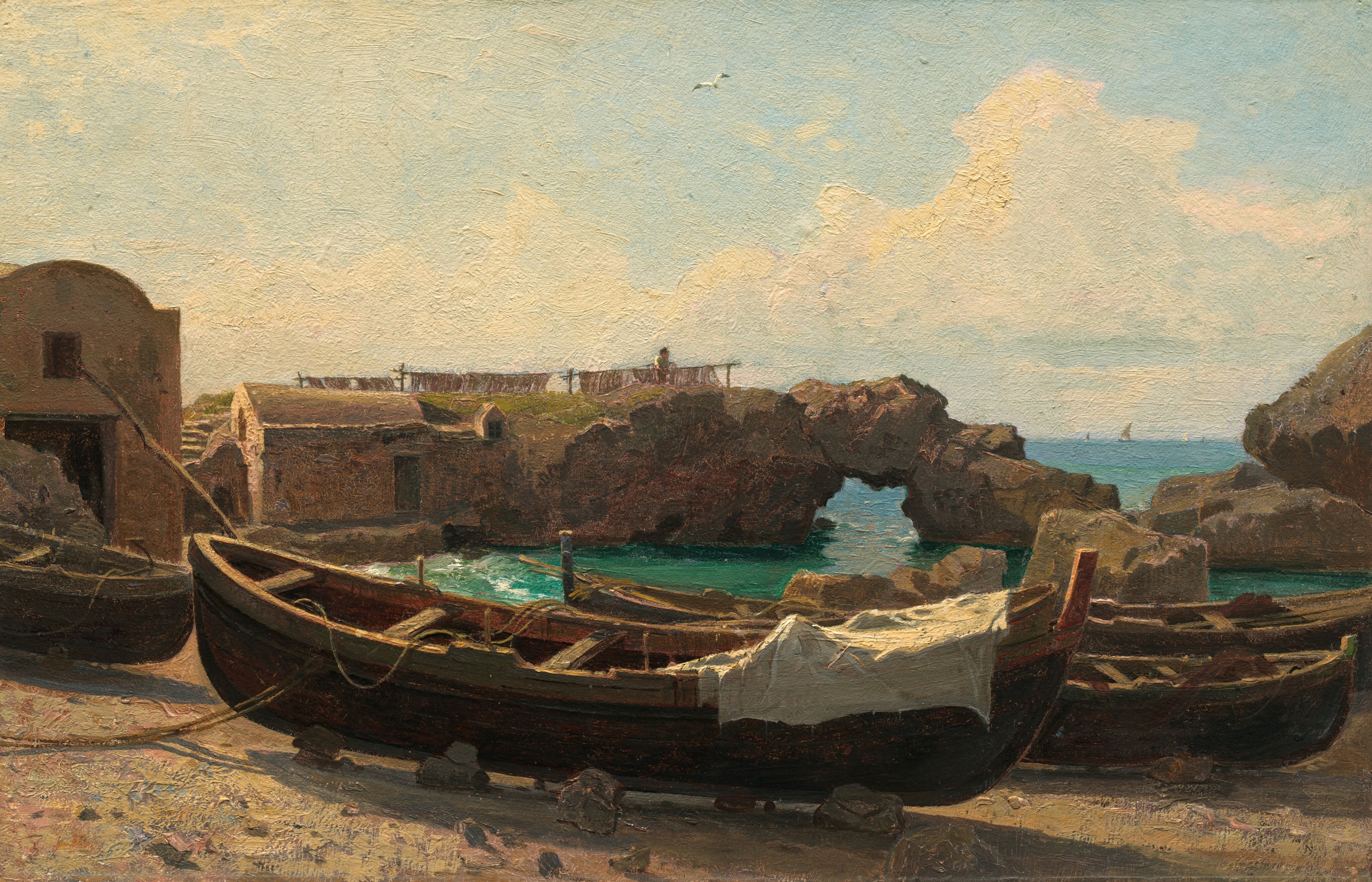 This painting shows a coastal scene with wooden rowboats on a sandy, rocky shore.  A white cloth and several ropes rest on the boat in the center, and two other boats are in a row behind it. On the left, brown stone structures are partially visible, with one in the background appearing to have been carved out of a rocky formation. A small figure is visible atop this structure, tending to what may be a clothesline. The rocks stretch across the painting, with some areas of bright, green-blue ocean visible around them. Small boats appear to sail on the water far in the distance. The light blue sky dominates the upper half of the painting, filled with puffy white clouds.