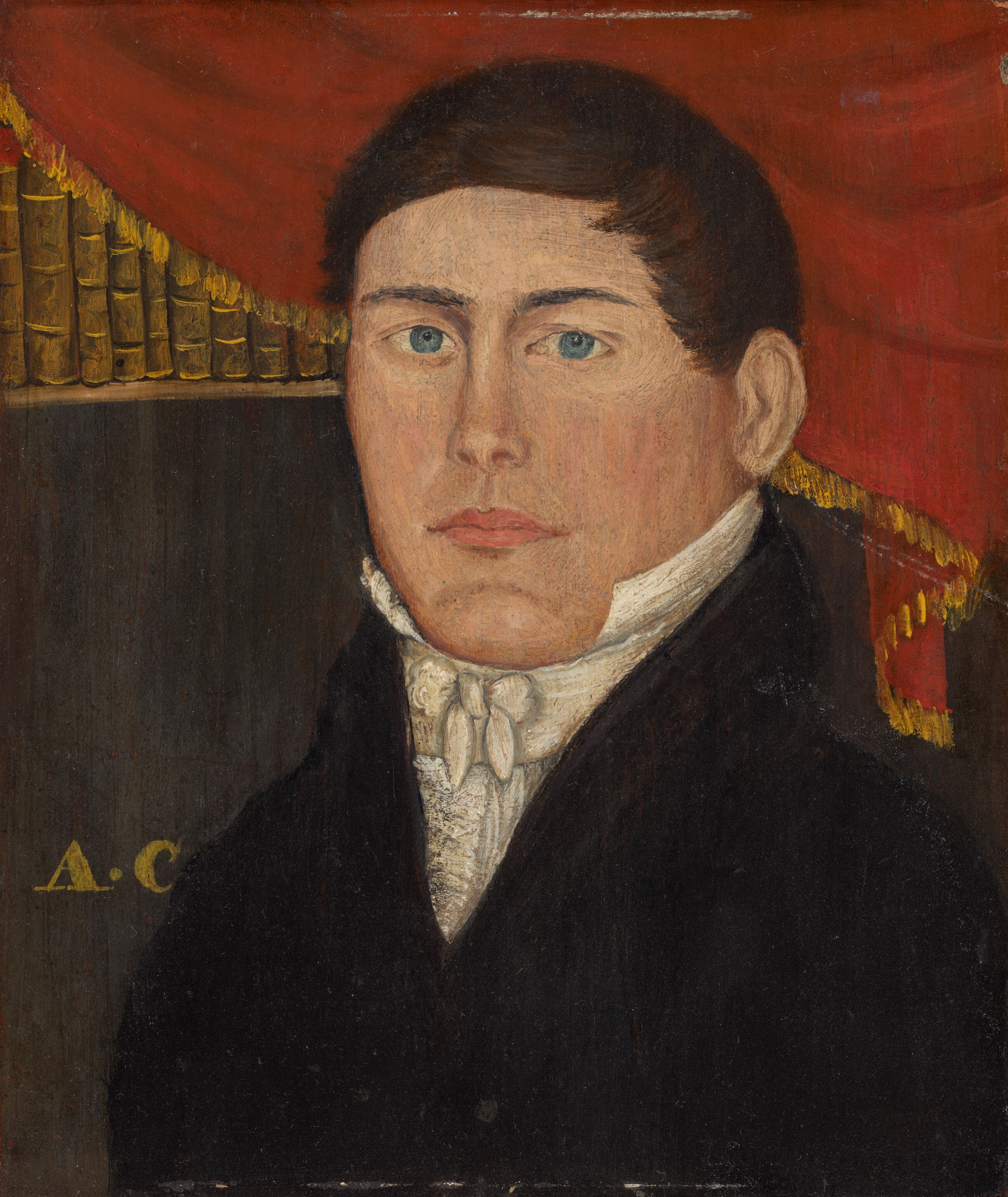 The image shows a head and shoulders portrait of a person facing forward. The person has light skin, blue eyes, and short dark brown hair. They wear a formal black coat over a high-collared white shirt with lace detailing and a white cravat. In the background, there is a red draped curtain with gold fringe and a row of books. The initials "A. C." are visible in gold letters on the dark background behind the person.