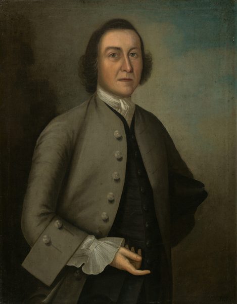 The image shows a man standing with his left arm bent across his waist. He has a serious expression, distinct facial features, brown hair, and is wearing an 18th-century outfit with a brown coat, white shirt, and ruffled cuff. His right hand is tucked into his coat. The background is plain with a gradient from dark brown to lighter shades.