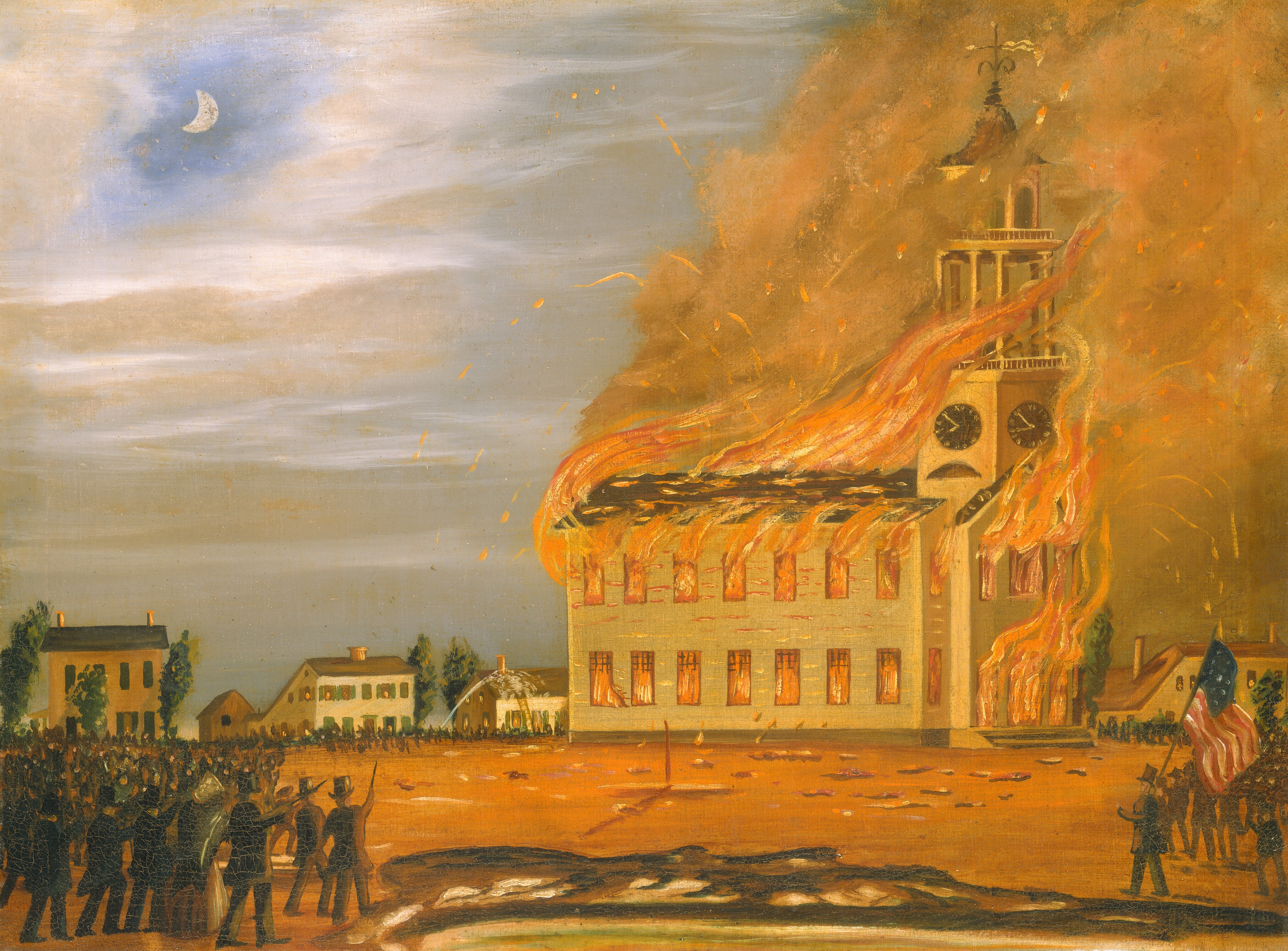The painting depicts a burning building. The large white building is in the center of the painting, and it faces the right, with two rows of windows, a black roof, and a large tower with a clock. Bright orange and red flames pour out of the windows and doorways, and the fire stretches upwards towards the tower. Dark gray smoke and orange sparks surround the building, filling up the right side of the painting. On the dirt ground around the building, crowds of small people in dark coats and hats gather and point towards the fire. One person near us holds an American flag. Behind the burning building, smaller buildings and trees are visible, and the cloudy sky above appears lit by a crescent moon in a small circle of light blue.