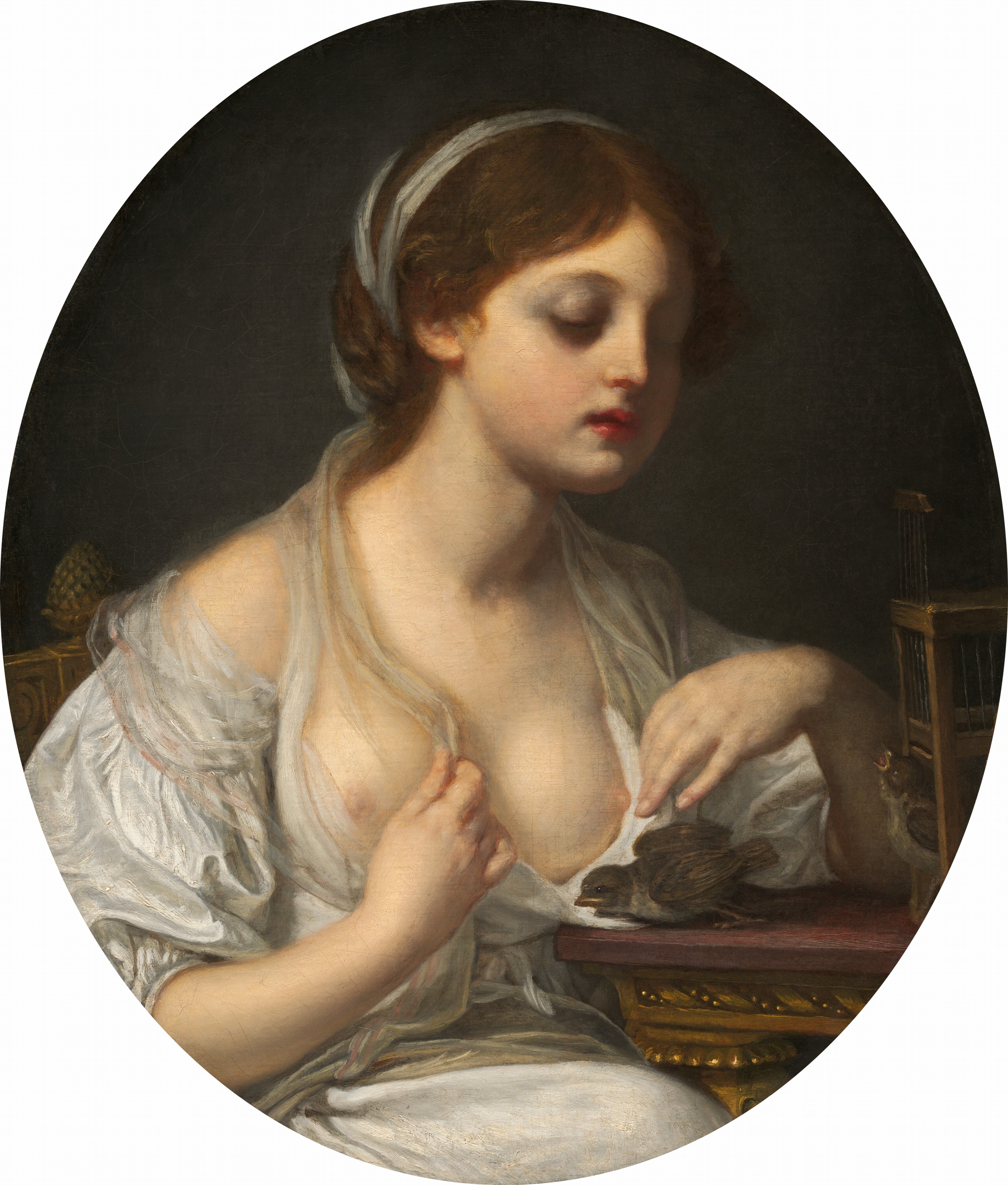 Shown from the waist up, a pale-skinned young girl sits next to a table with two small brown birds in this vertical, oval-shaped portrait. The girl’s body is angled to our right, and she looks down her cheeks at the birds. Her heavy lids are pale purple, and she has a delicate nose, full, red lips, and a round chin. Her brown hair is parted down the middle and pulled back under a white band. Her white gown is loose over her chest, exposing both round breasts and pale nipples. She holds the cloth to each side of her left breast, farther from us. A bird at the edge of the table leans forward toward the girl. The second bird pokes its head out of a box-like cage and looks up, beak open. The table has a mauve-purple top over a carved gold apron and leg. The girl’s chair has a nut-shaped finial on one rail, and the background is dark gray.